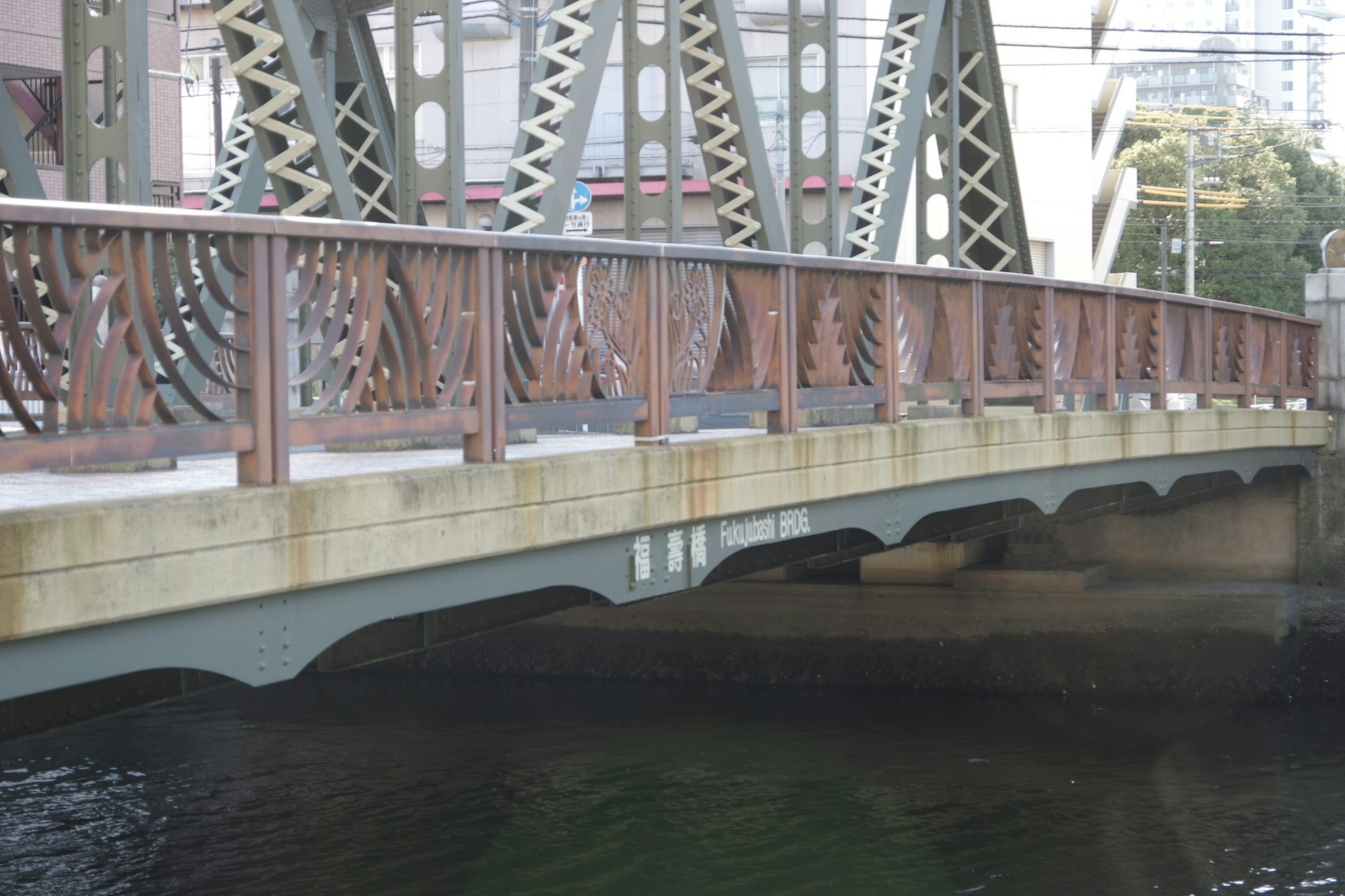 Parte di un ponte in metallo con parapetto in legno sopra la superficie dell'acqua