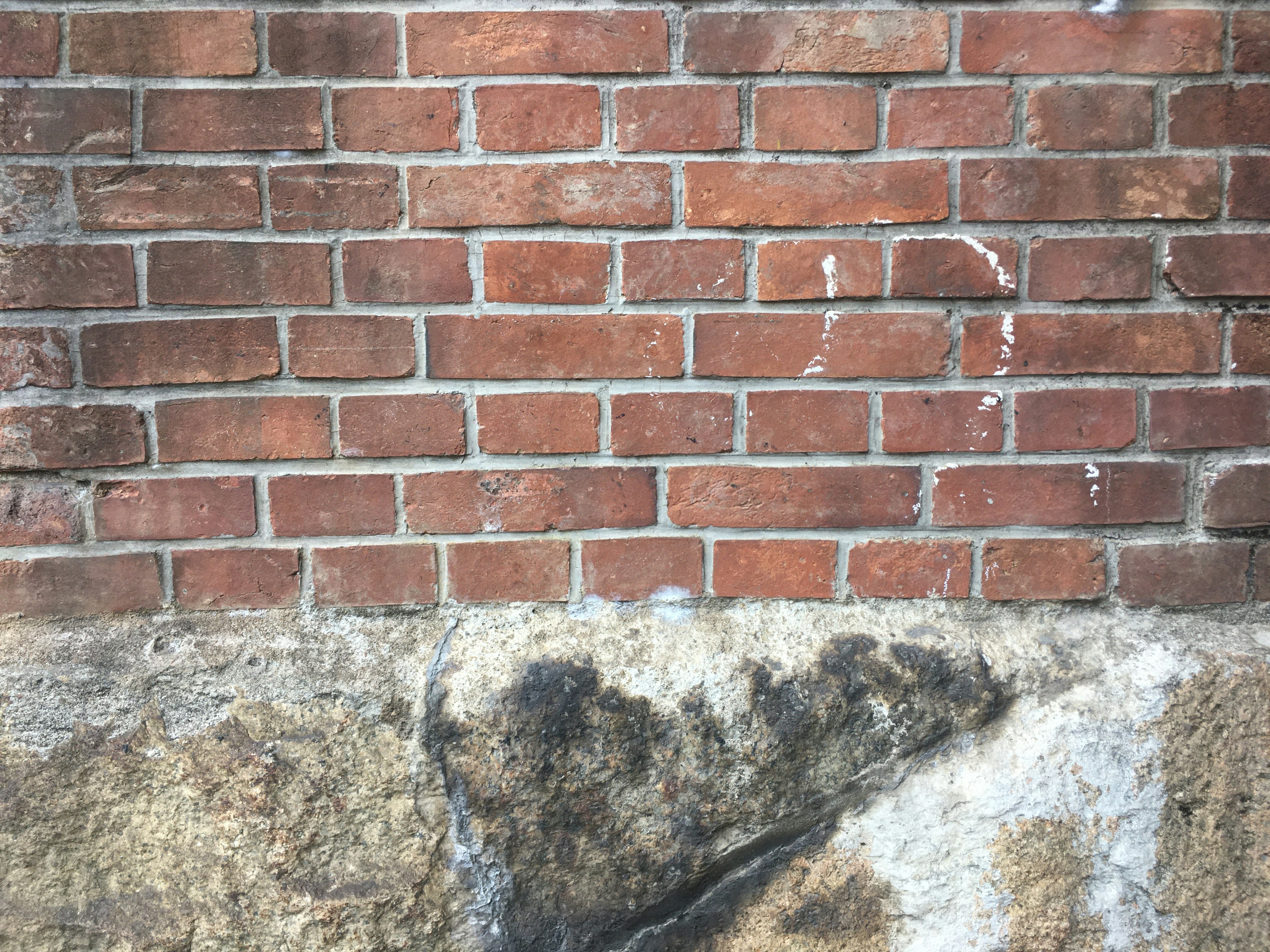 Image d'un mur en briques avec une fondation en pierre