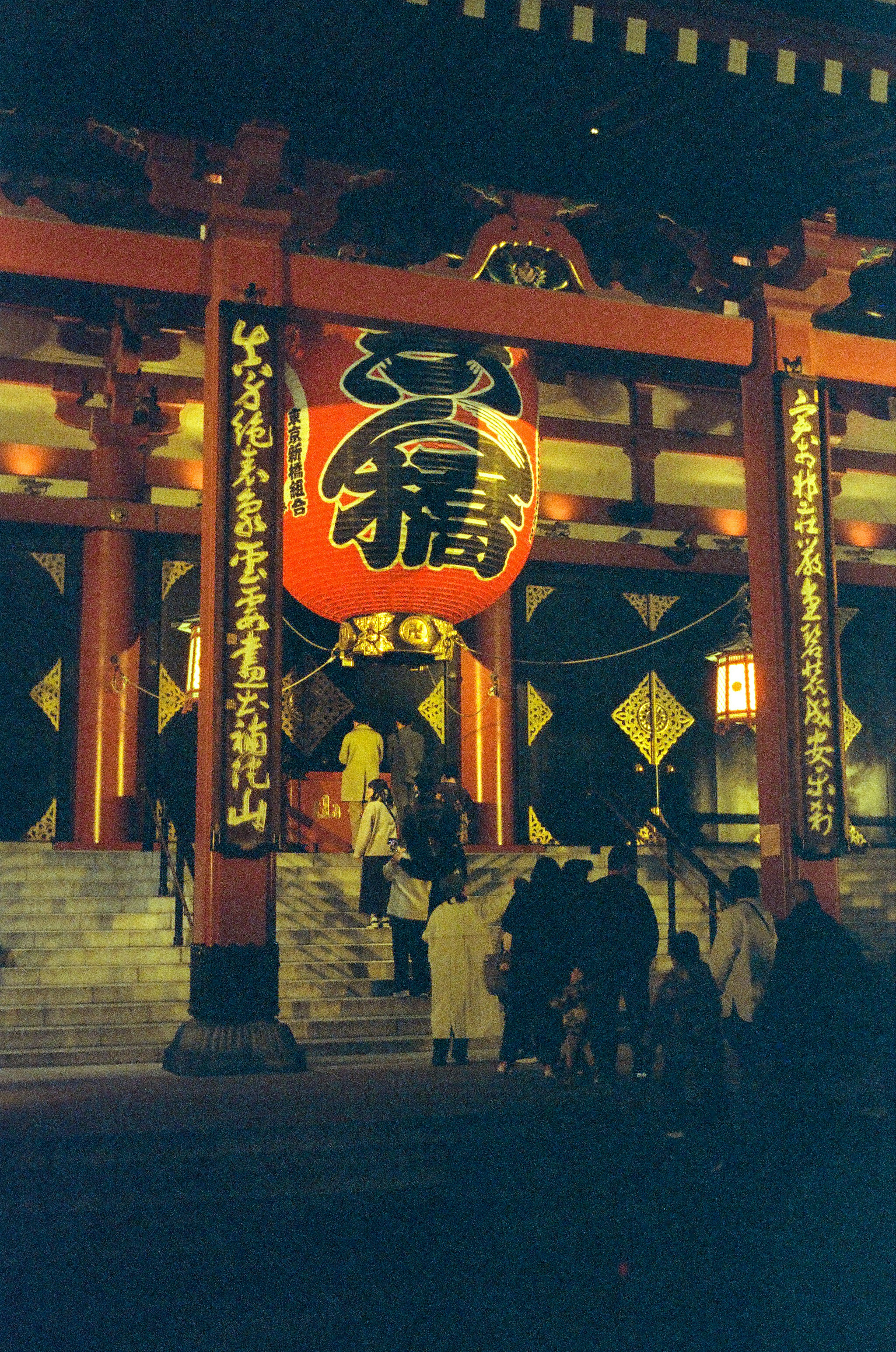 Une vue frappante d'un torii rouge et d'une grande lanterne la nuit dans un sanctuaire