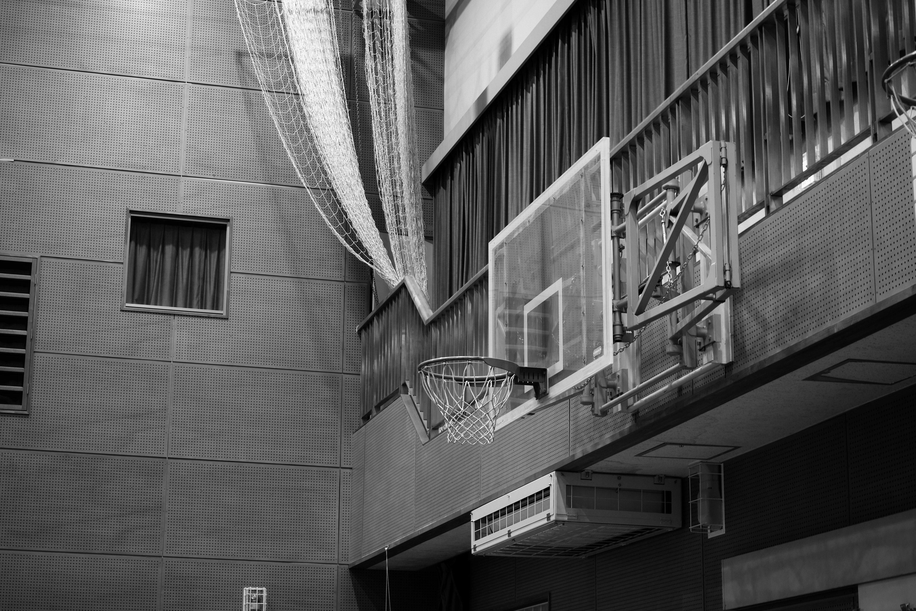 Interior de un gimnasio con un aro de baloncesto y red