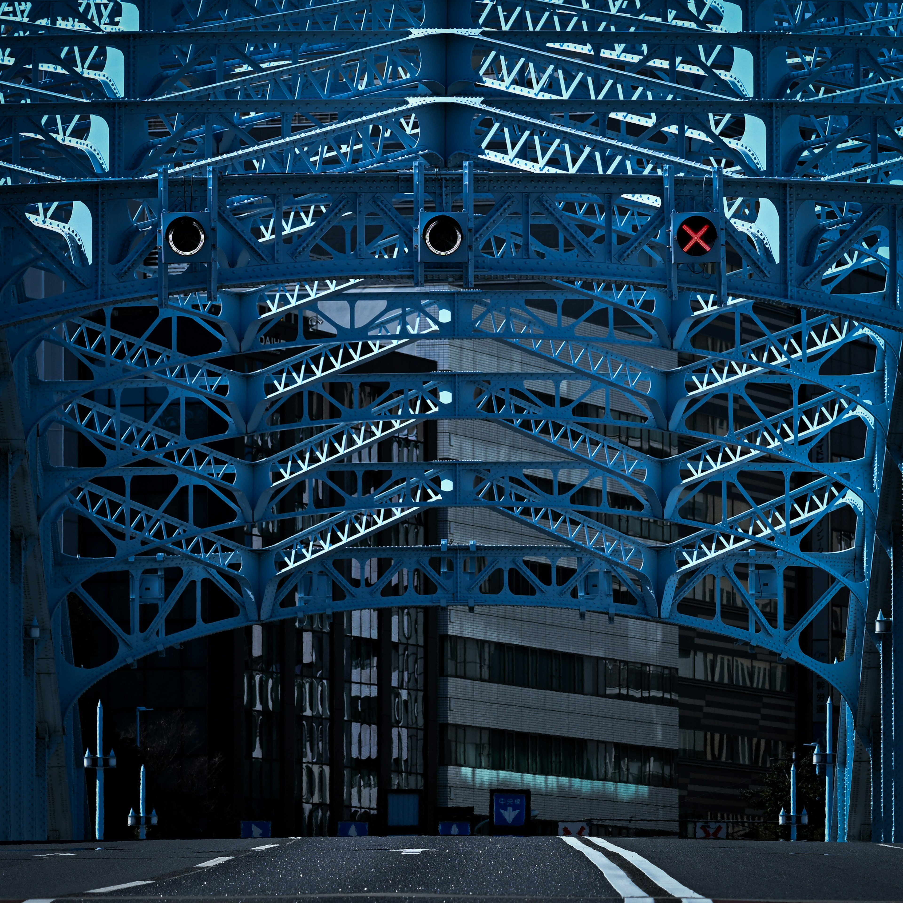 Urban scene featuring a blue bridge structure with buildings in the background