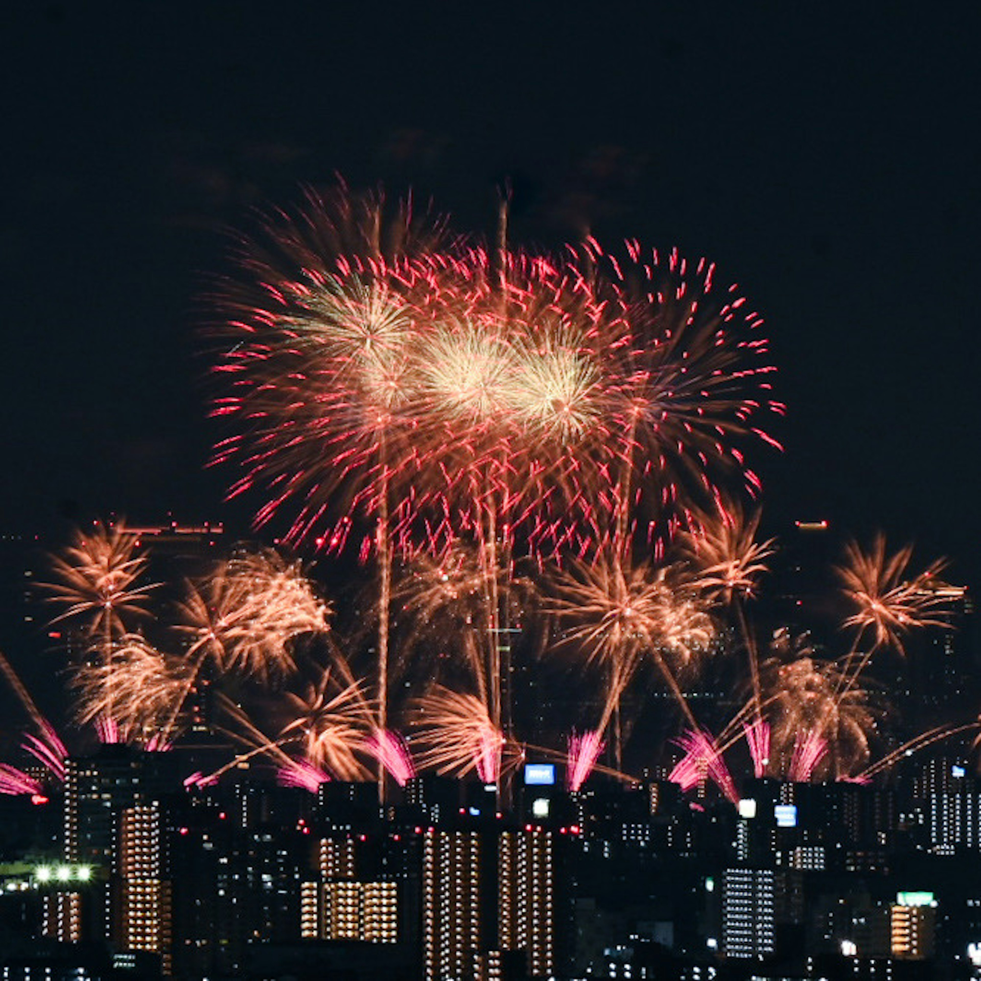 夜空に咲く花火の美しい光景と都市のシルエット