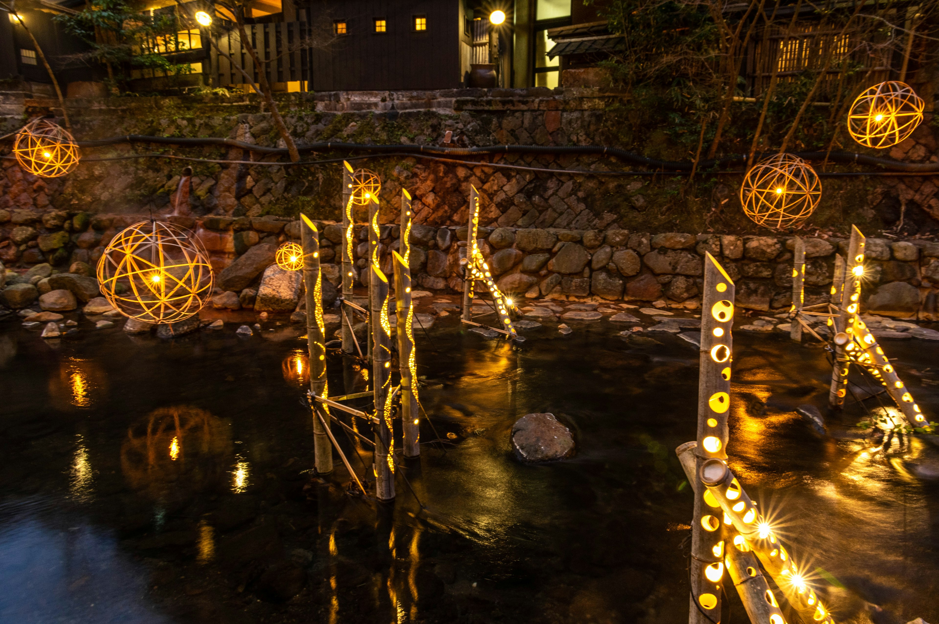 Beautiful night scene with glowing orbs and bamboo structures on a pond