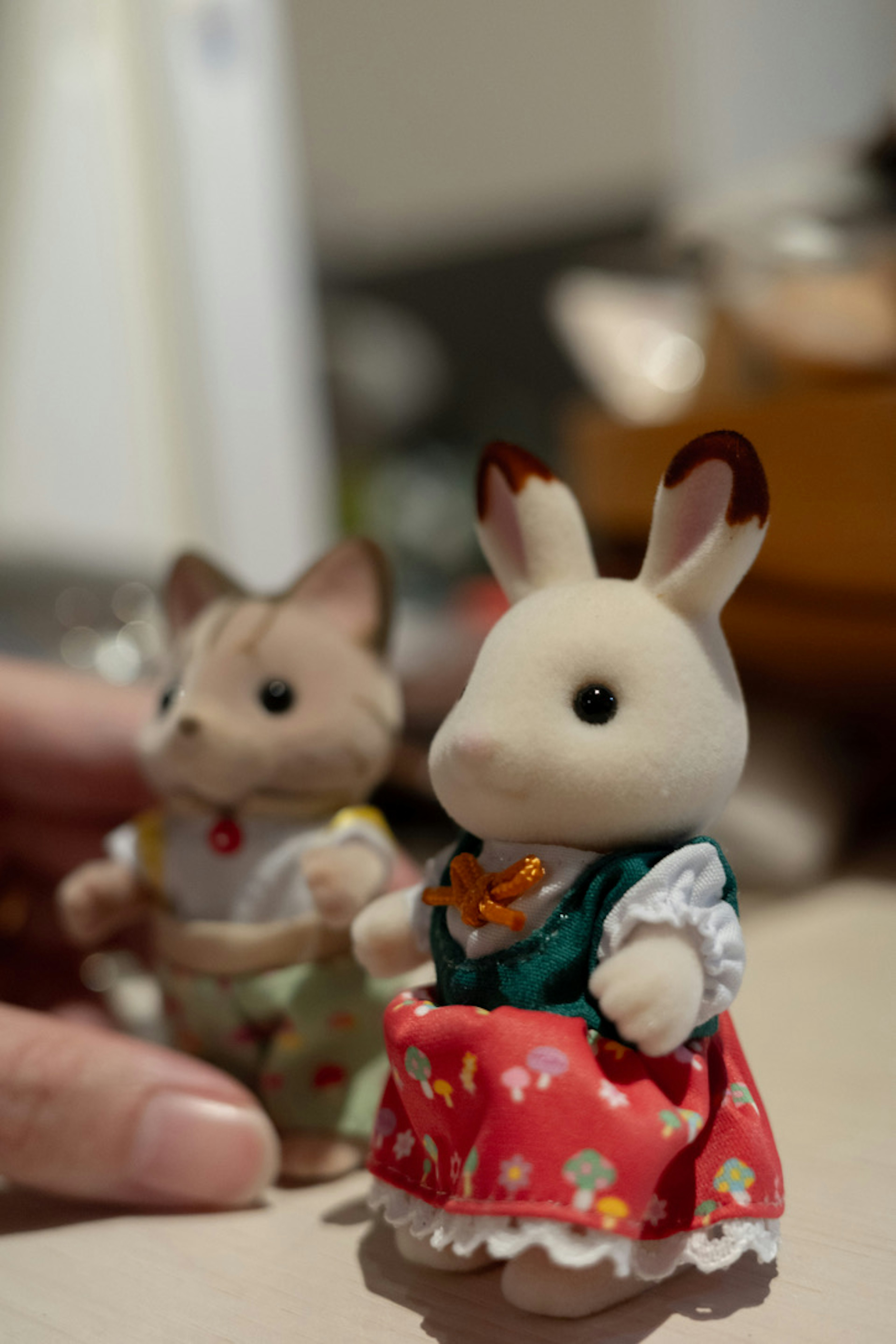 A photo of a rabbit and cat figurine standing side by side