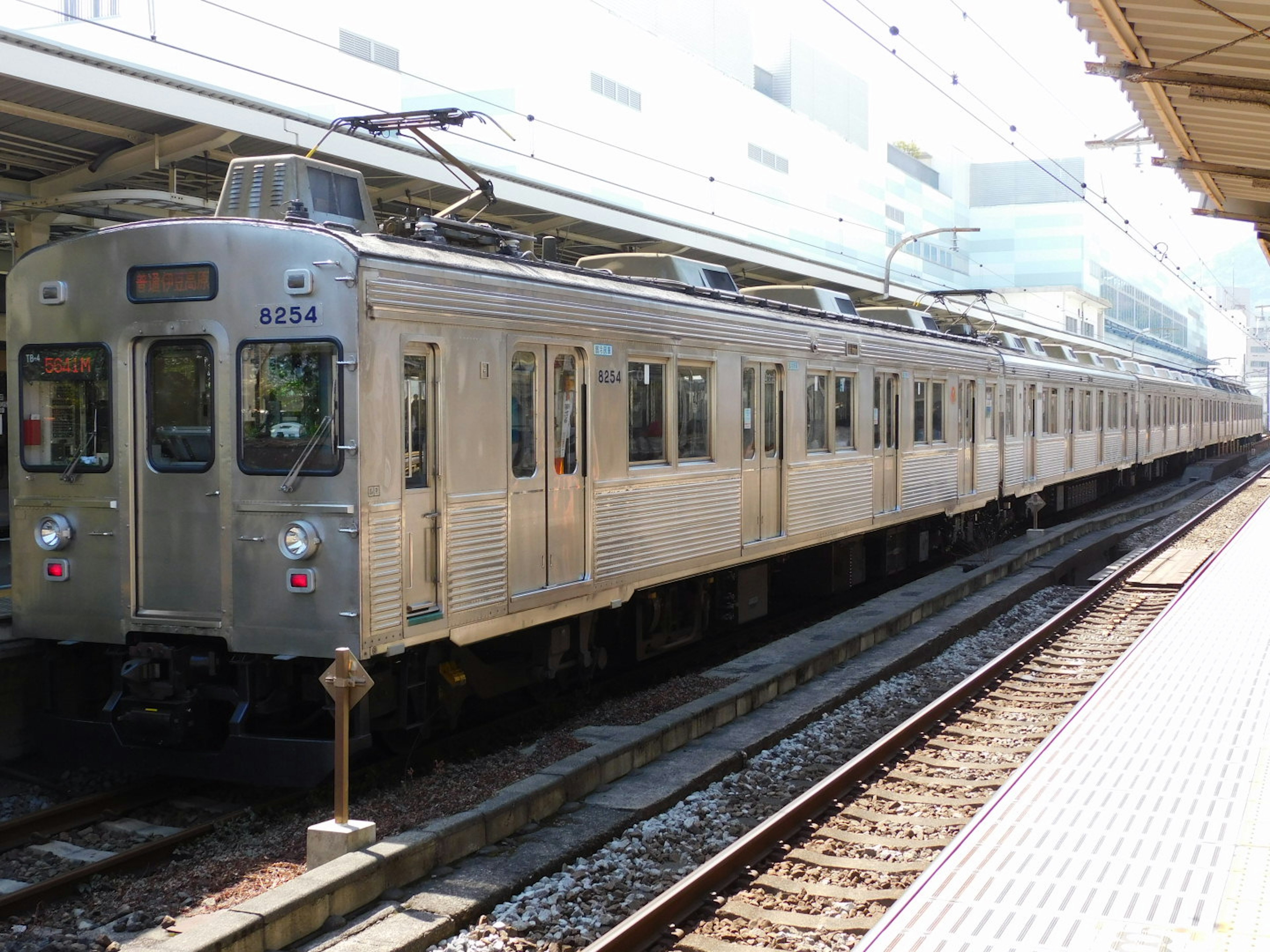 รถไฟสีเงินที่สถานีมีหลายตู้ปรากฏอยู่