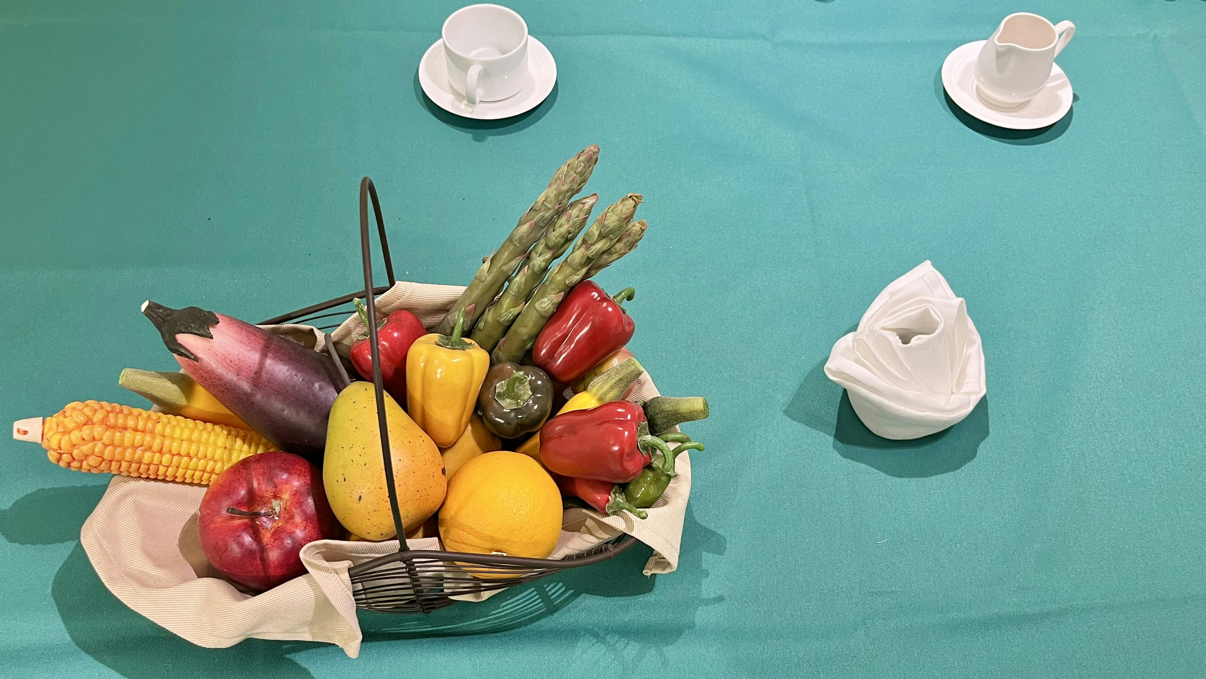 果物と野菜が盛り込まれたバスケットとテーブルに置かれたカップ