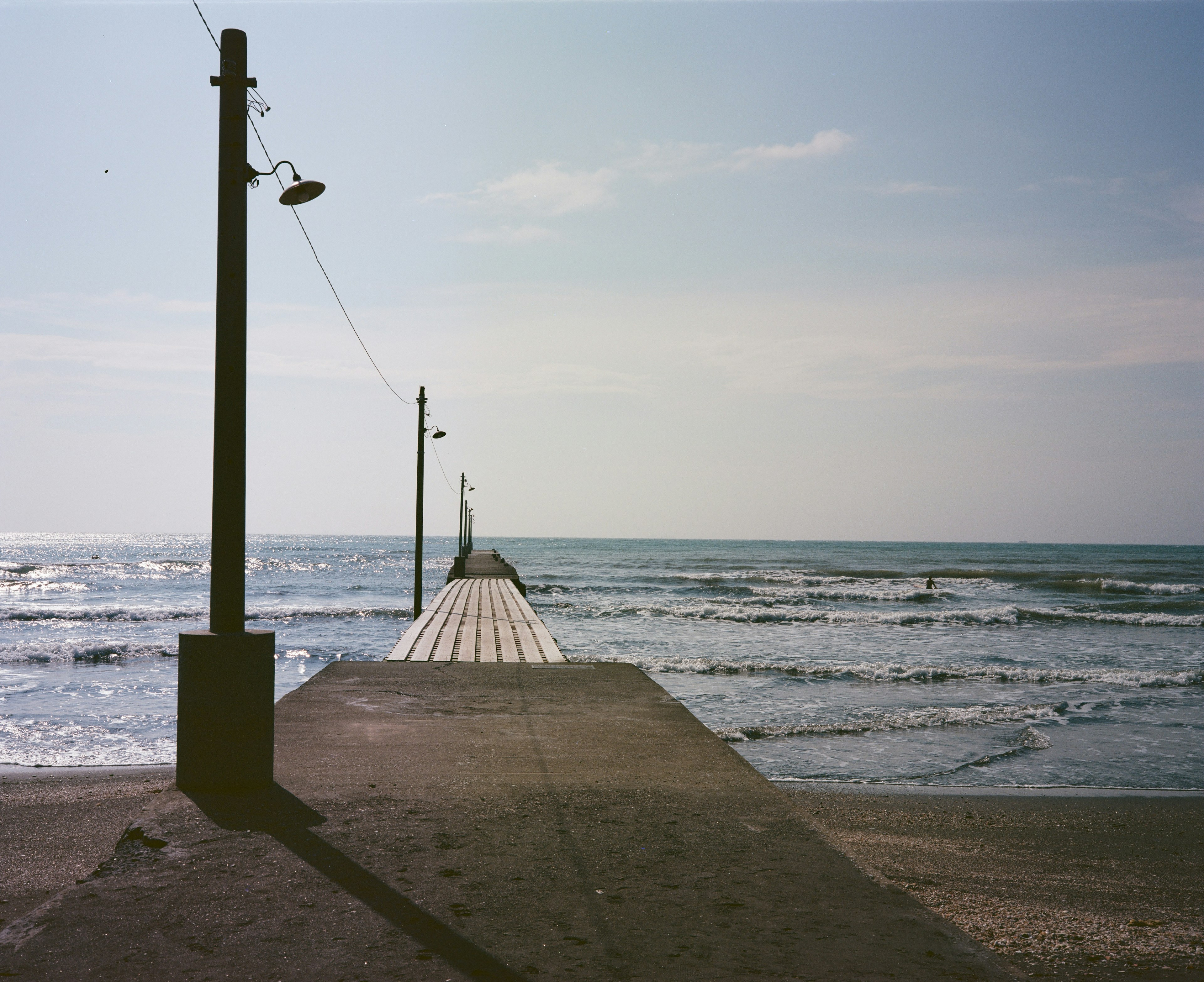 Long pier extending into the sea with gentle waves