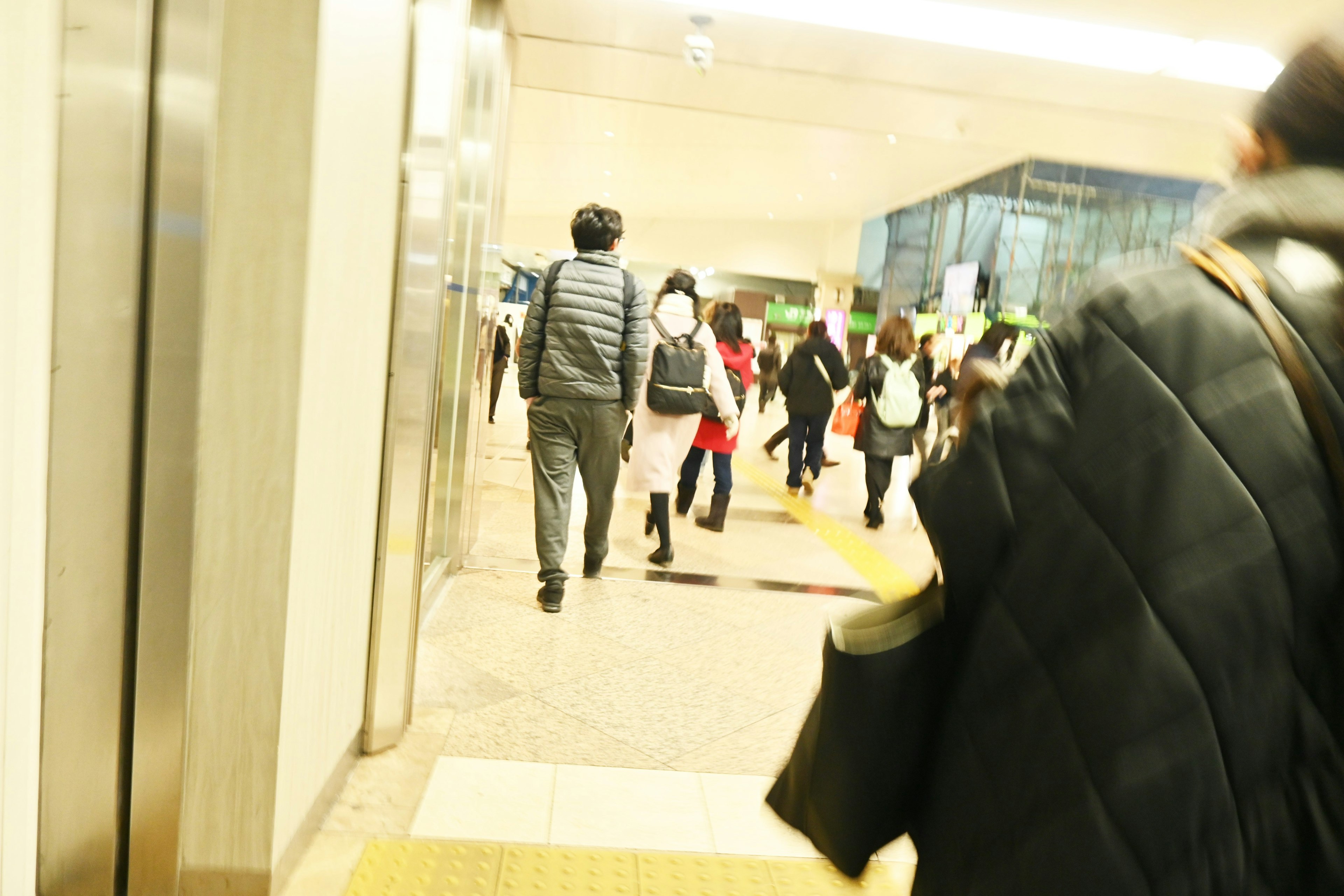 People walking in a busy station corridor