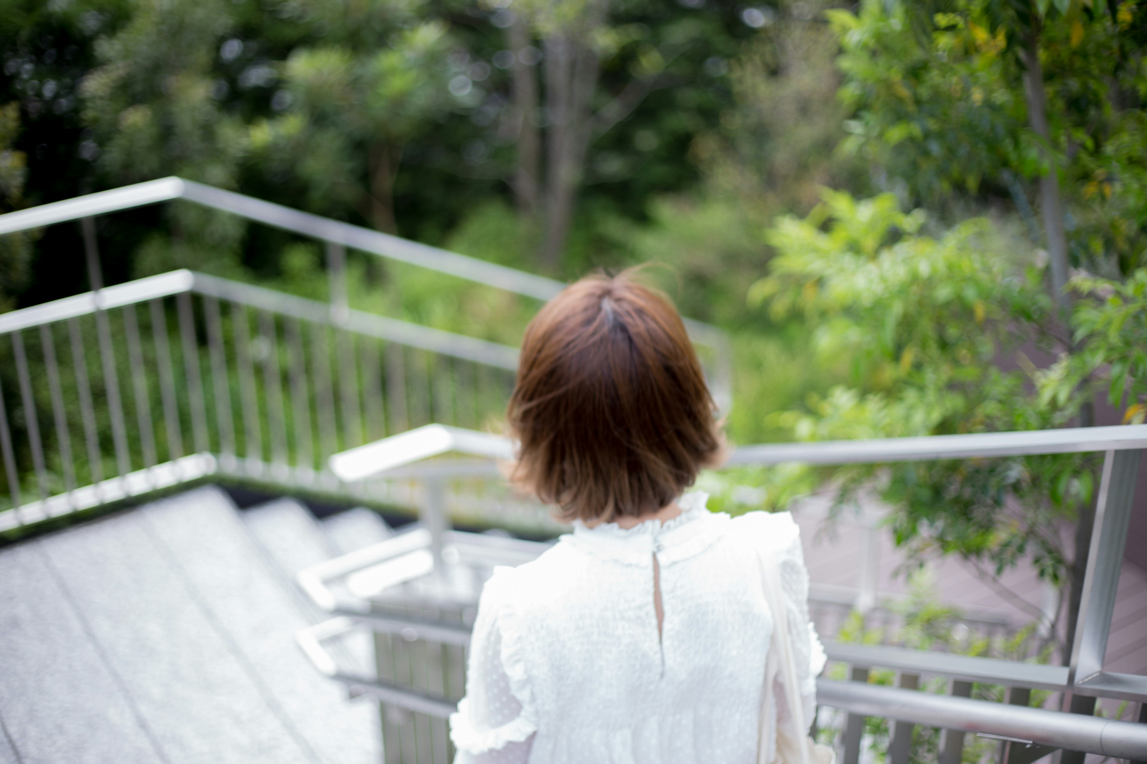 Woman descending stairs with a blurred background of greenery