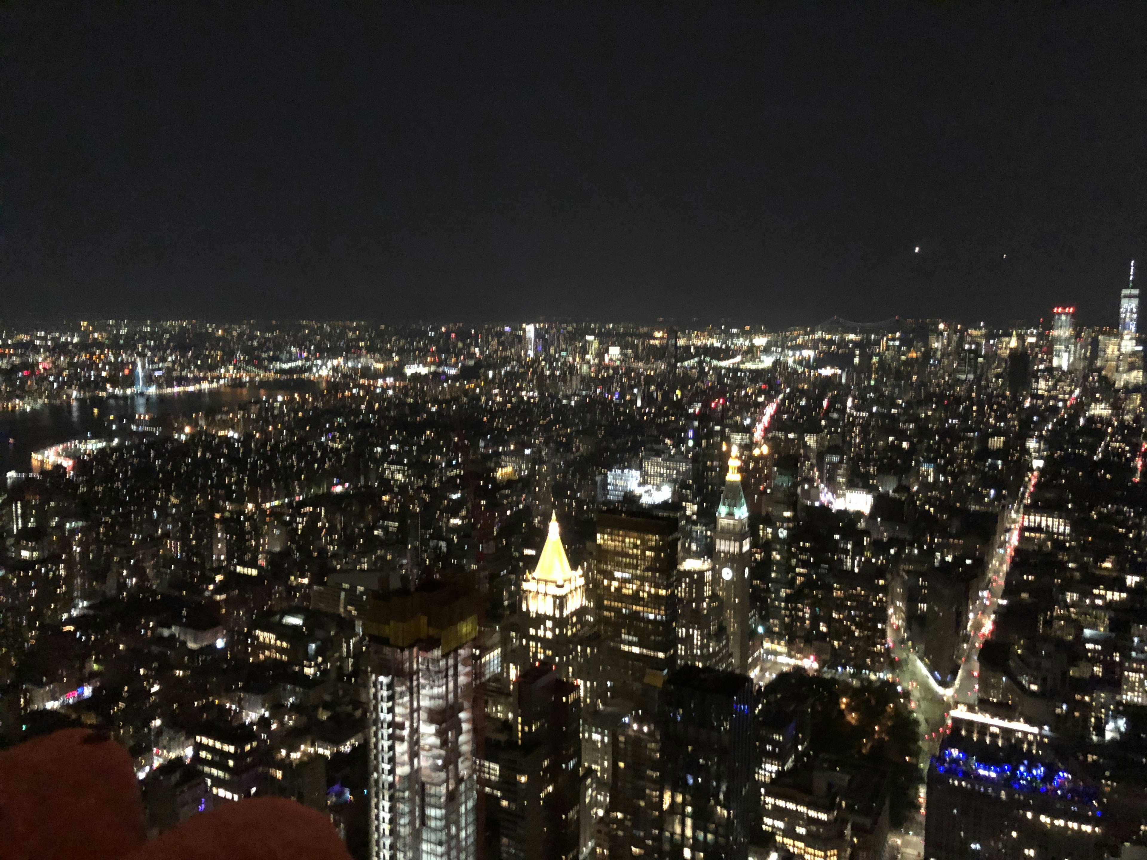 Panoramic view of New York City at night featuring skyscrapers and bright city lights