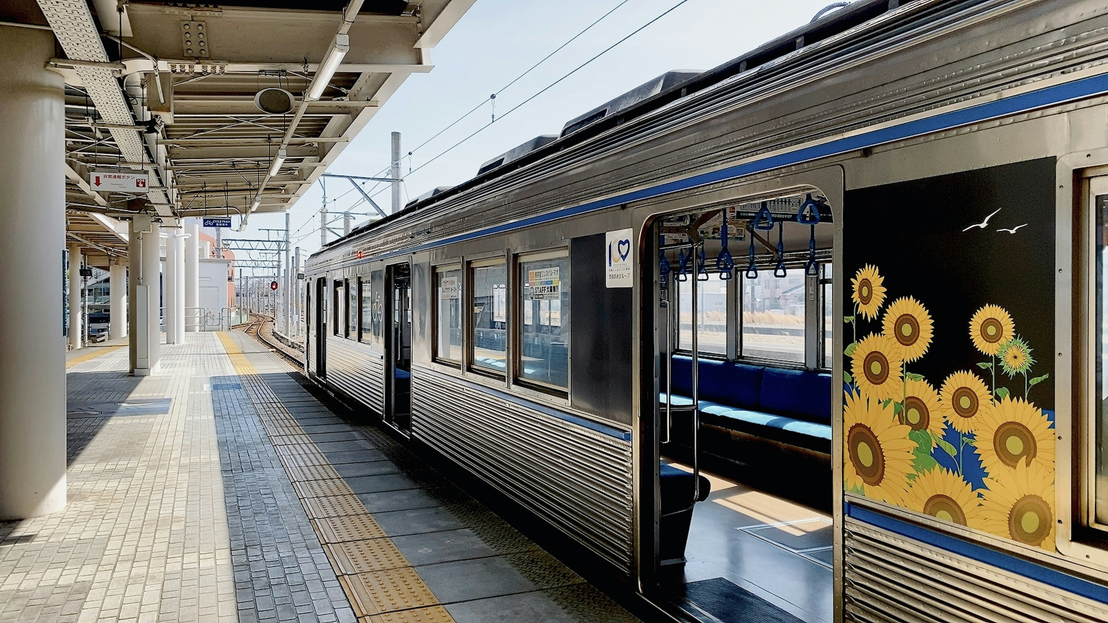 Train at a station platform with a floral design on the side