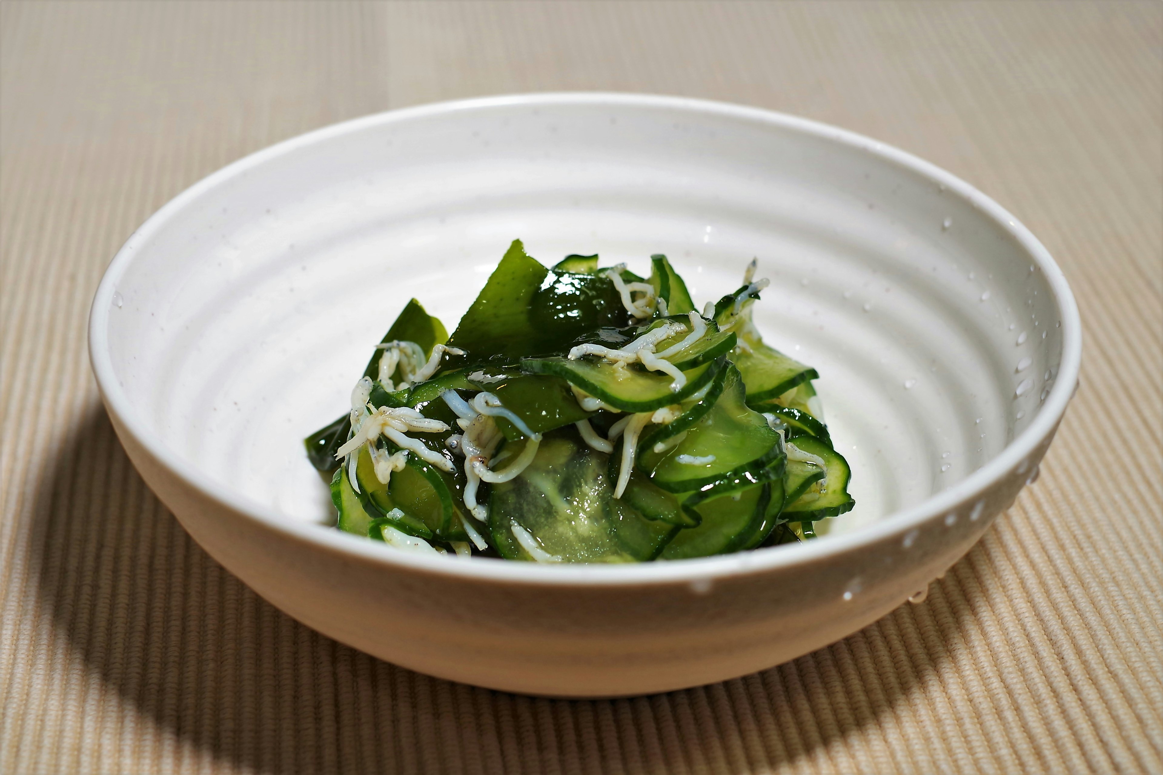 Cucumber and seaweed salad served in a white bowl