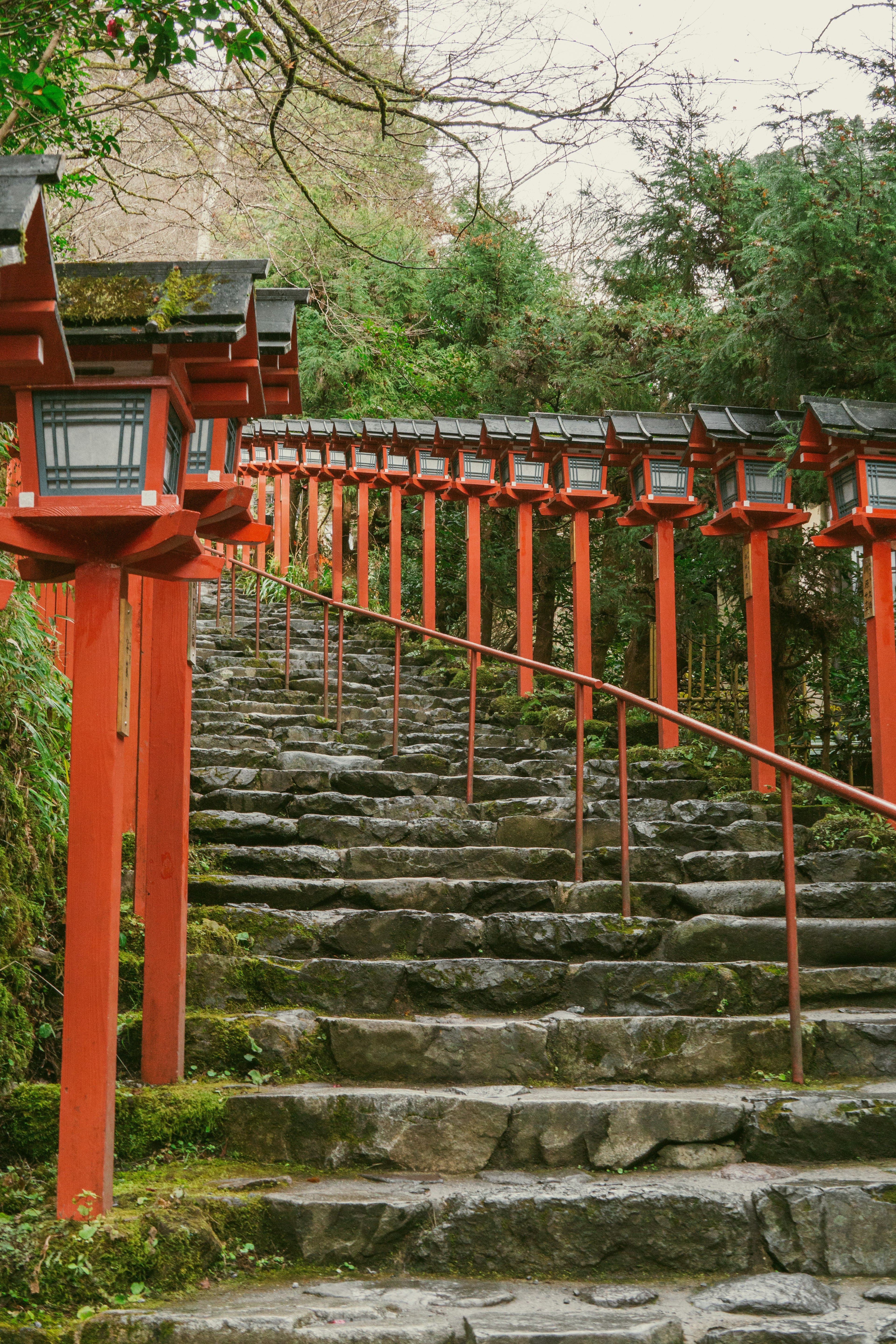 石の階段を上る赤い灯篭が並ぶ美しい風景