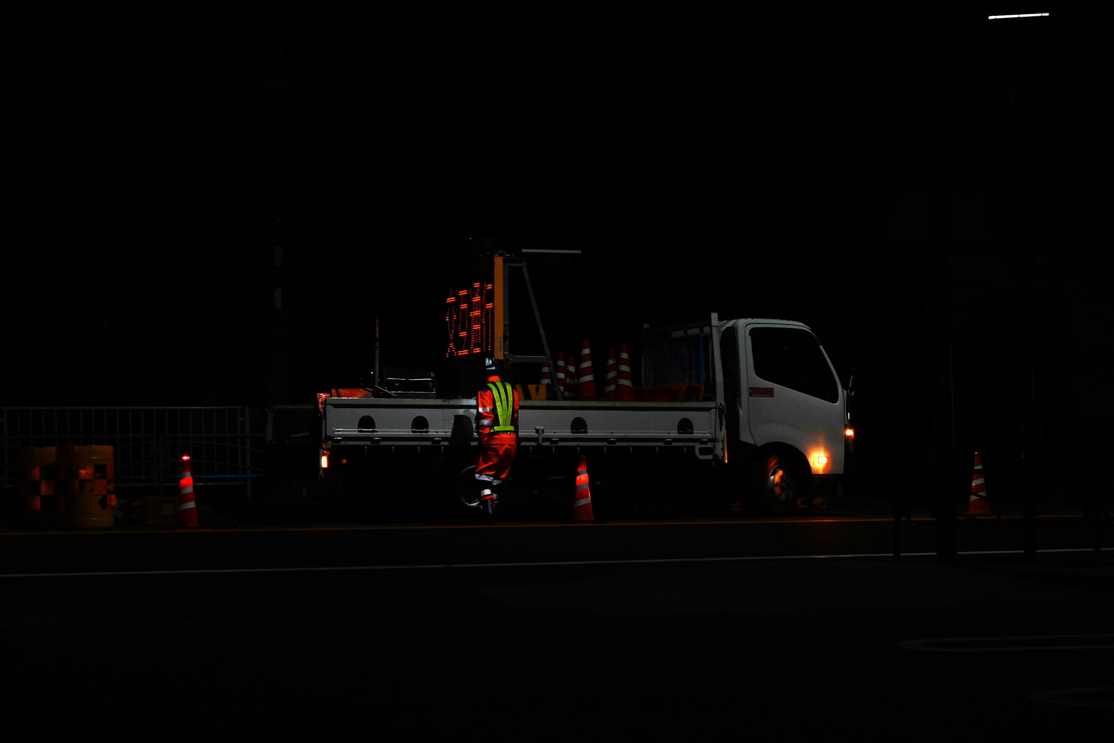 Worker and truck at a nighttime worksite