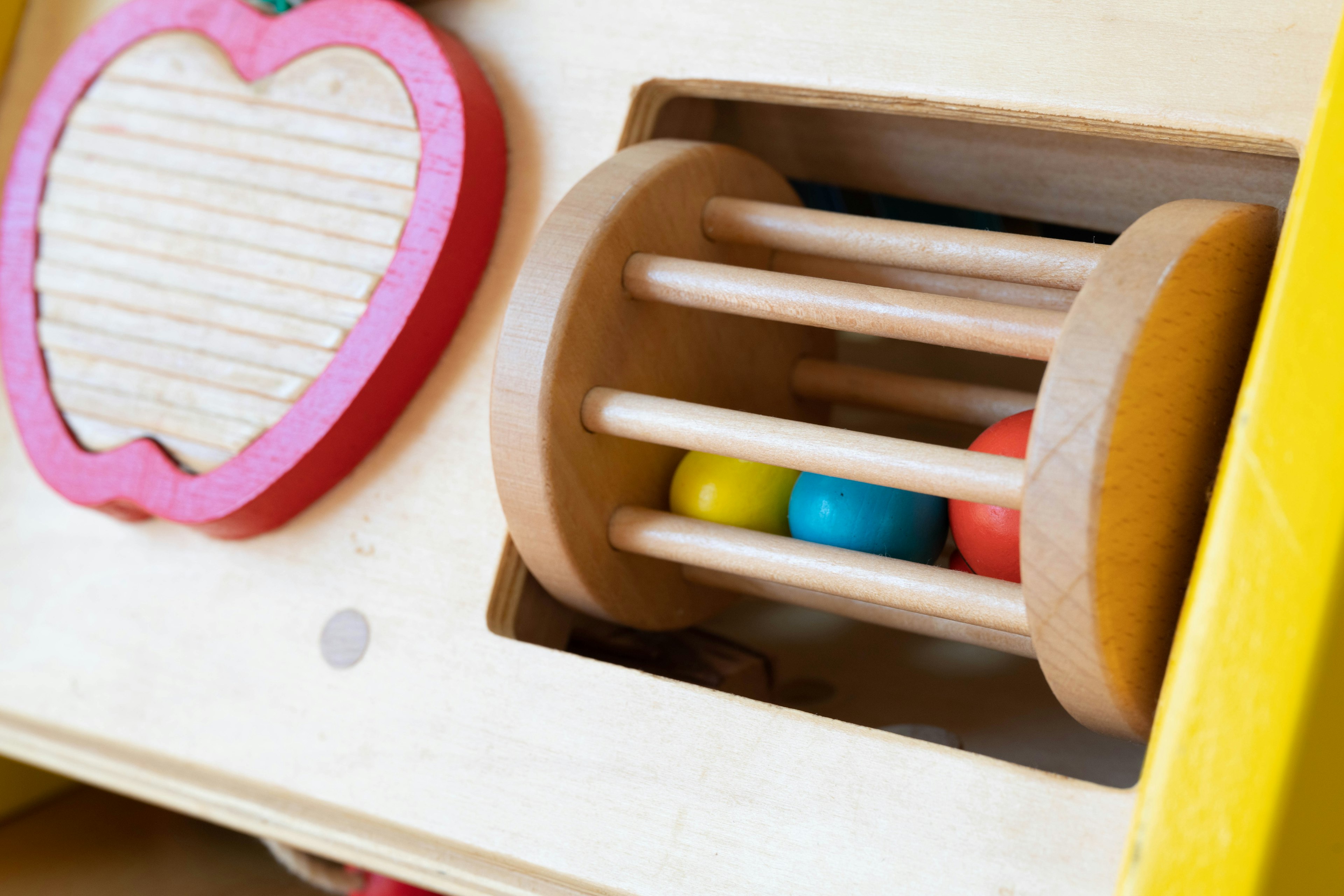 Colorful balls in a wooden toy section featuring a red apple design