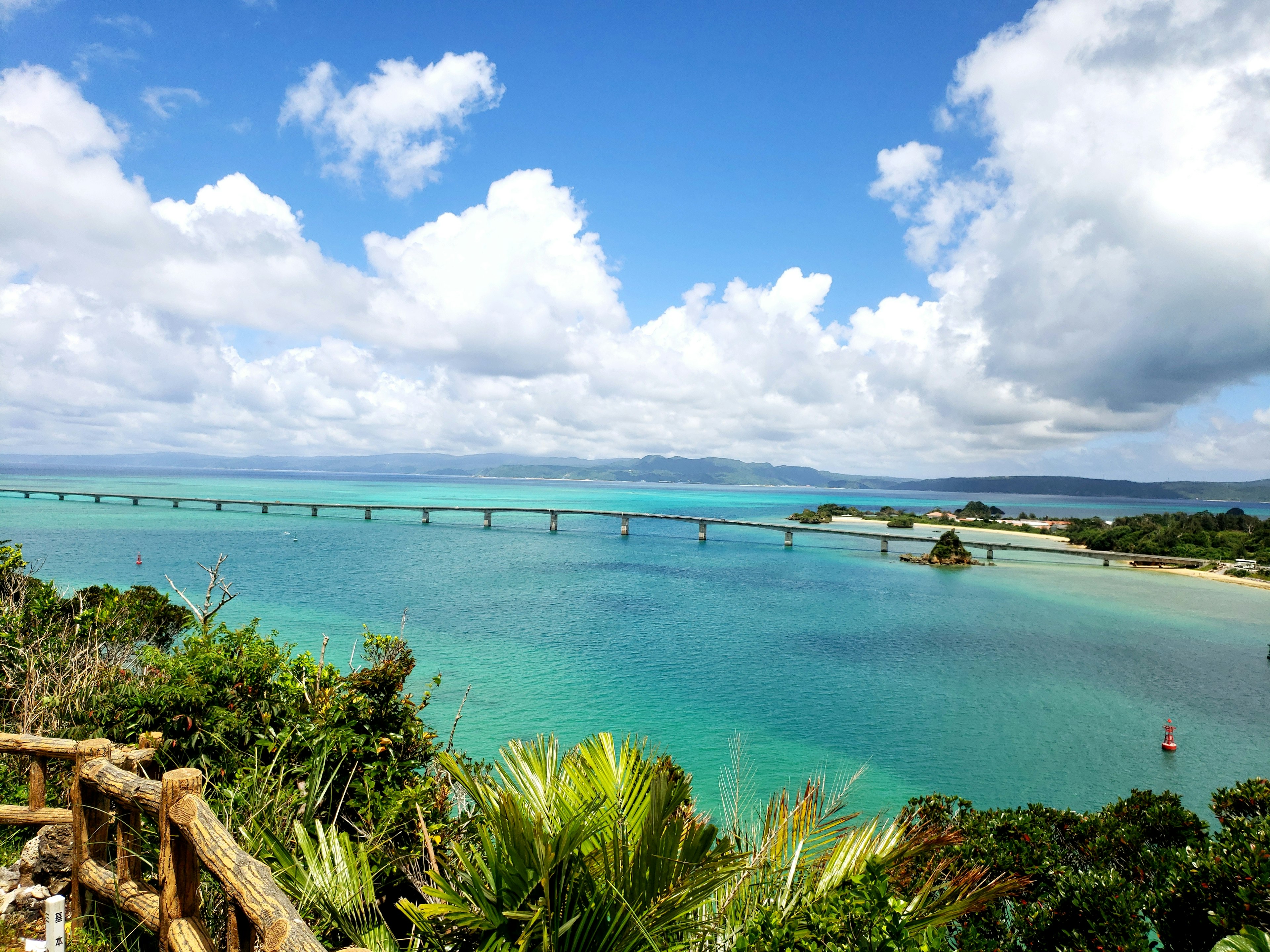 Scenic view of a blue ocean and sky with a visible bridge