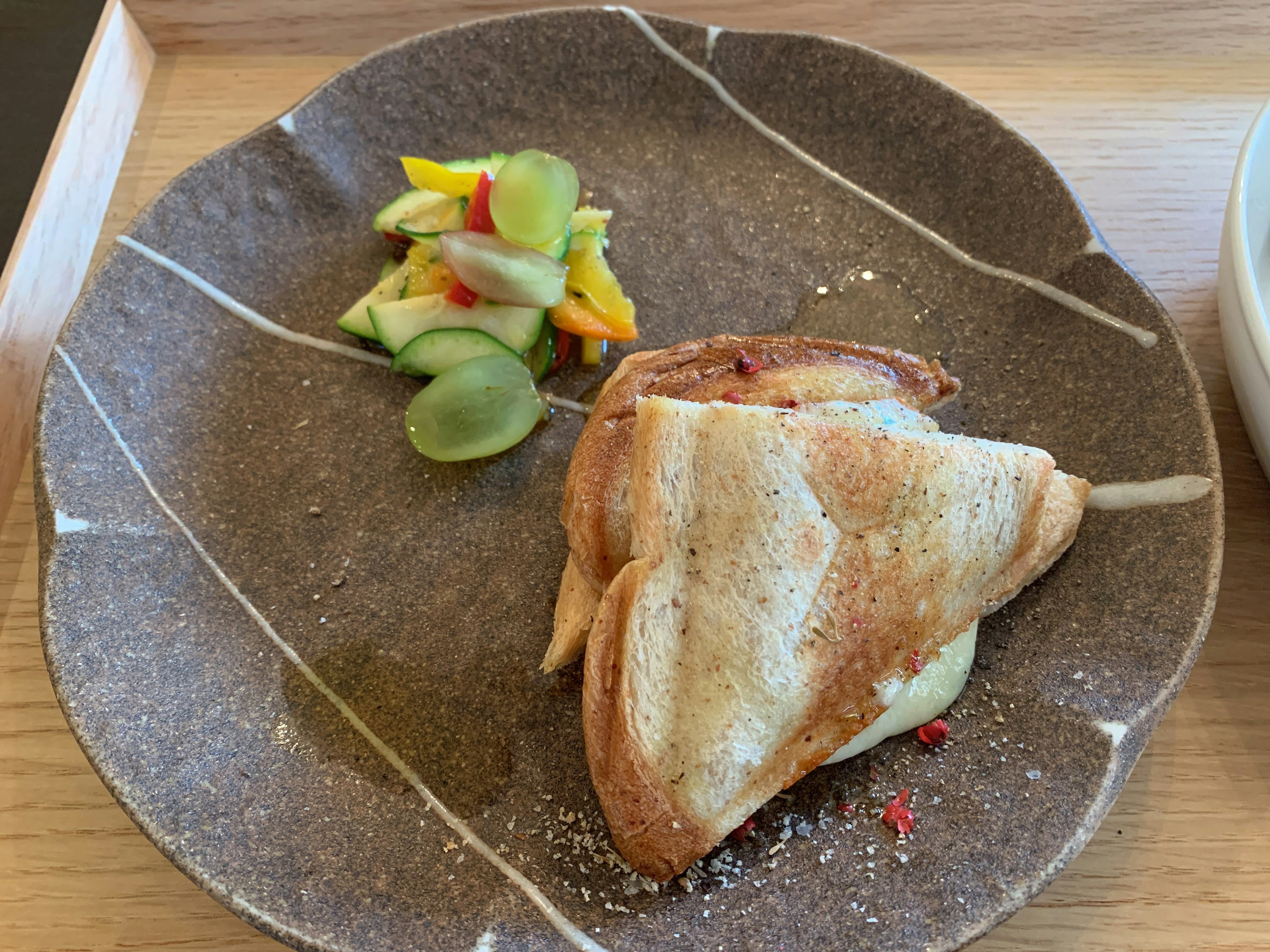 Panino tostato servito con un'insalata di frutta colorata