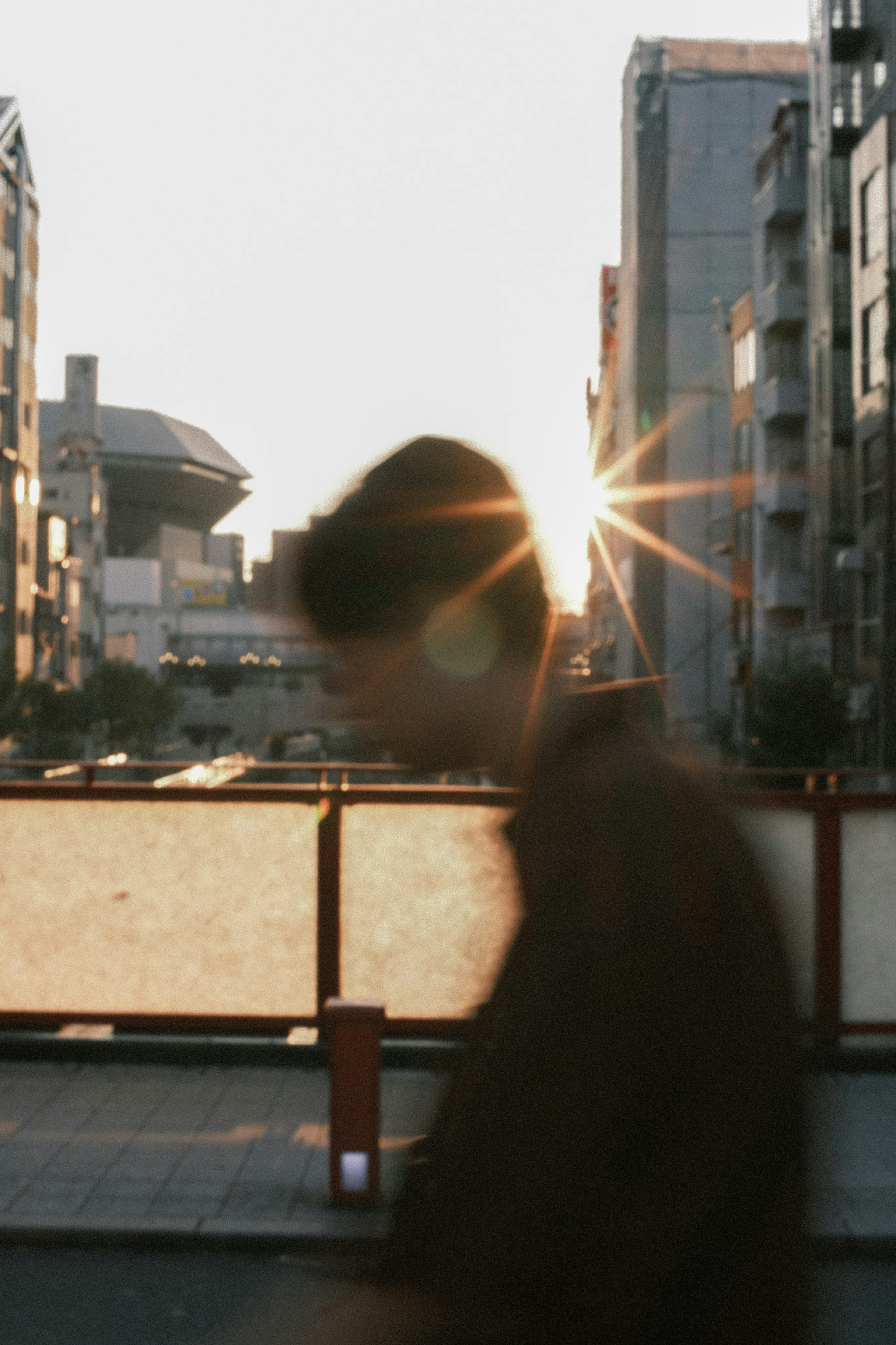 夕日を背にした人が歩く都市の風景