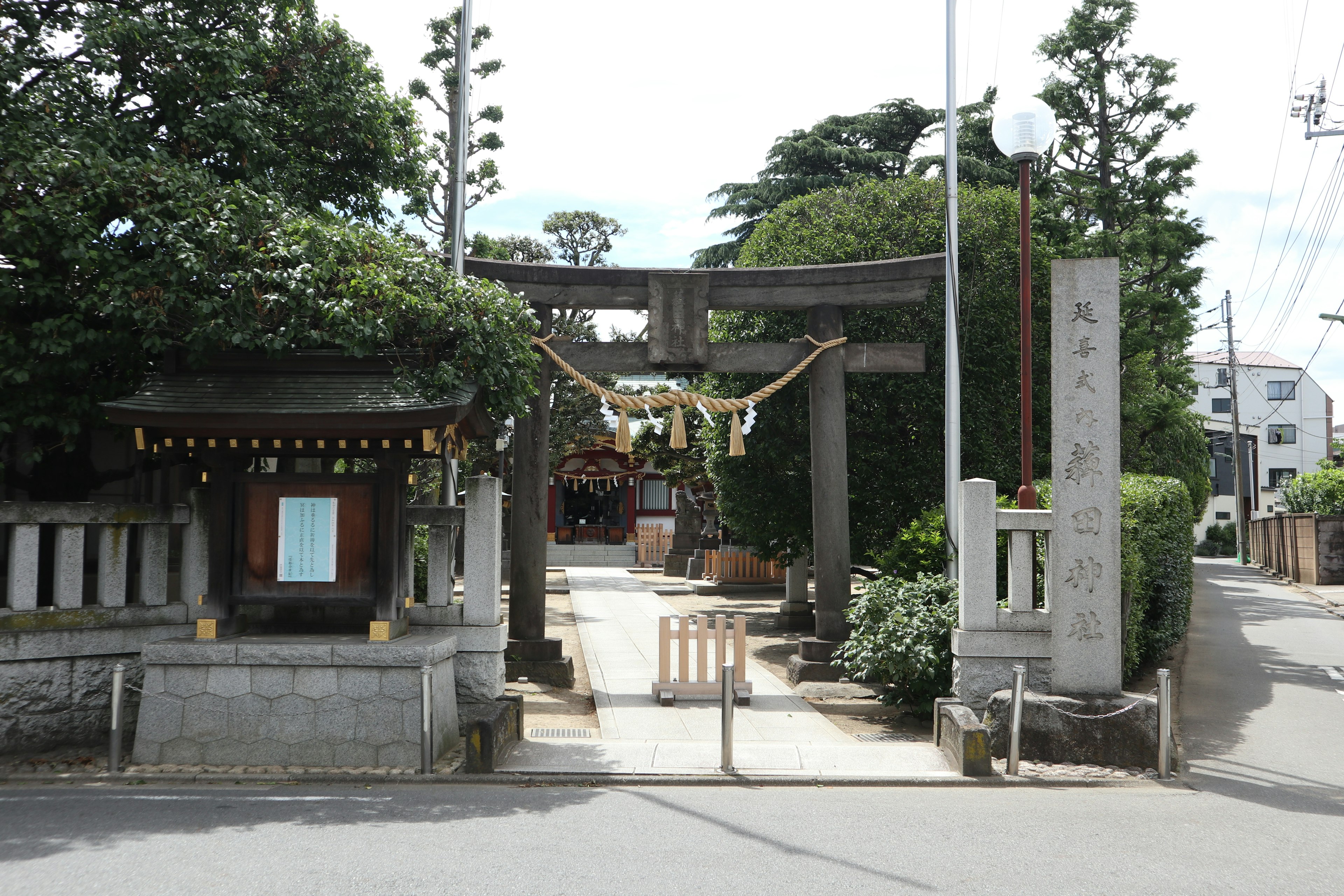 Pemandangan kuil dengan gerbang torii dan jalan masuk