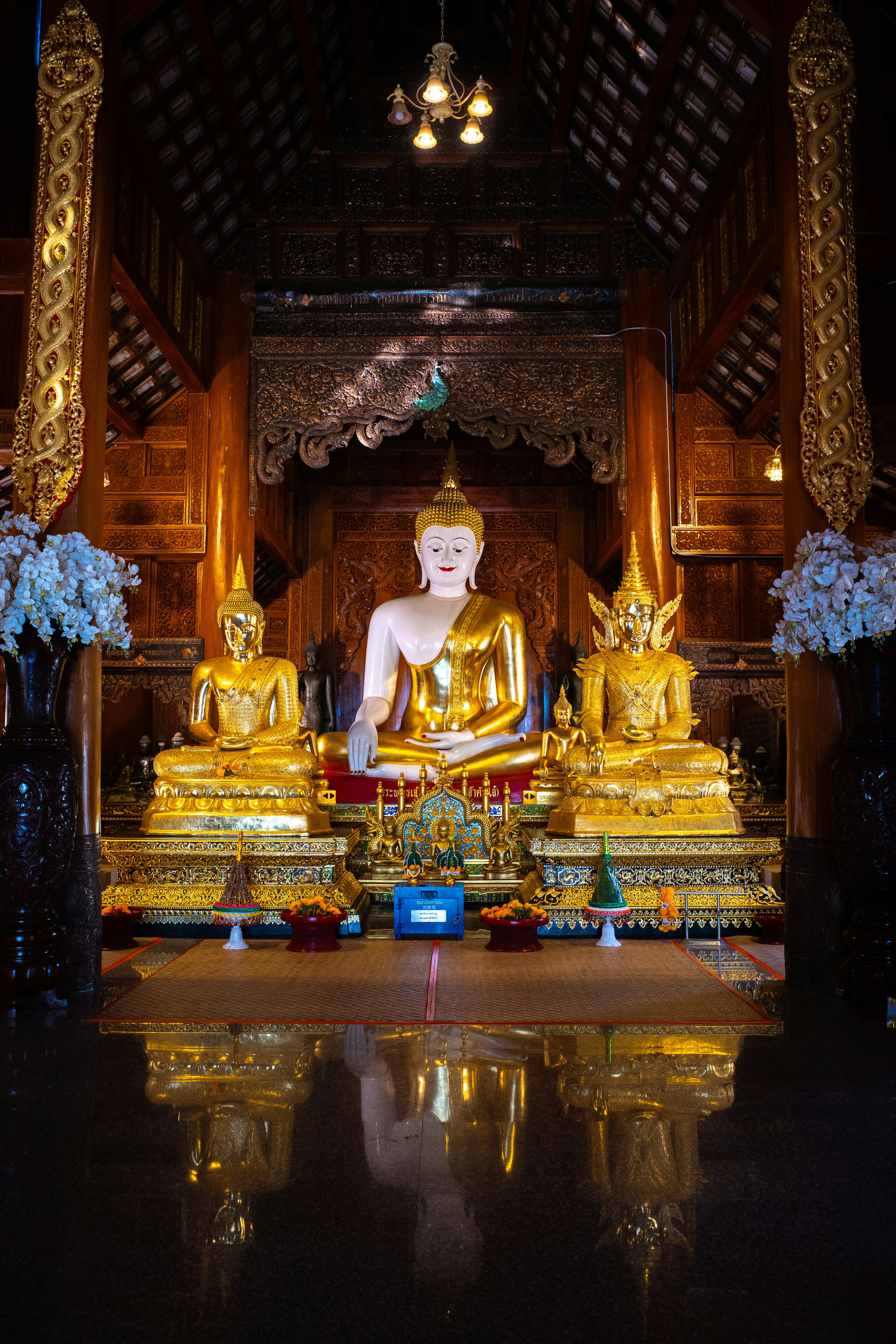 Interior view of a temple featuring golden Buddha statues