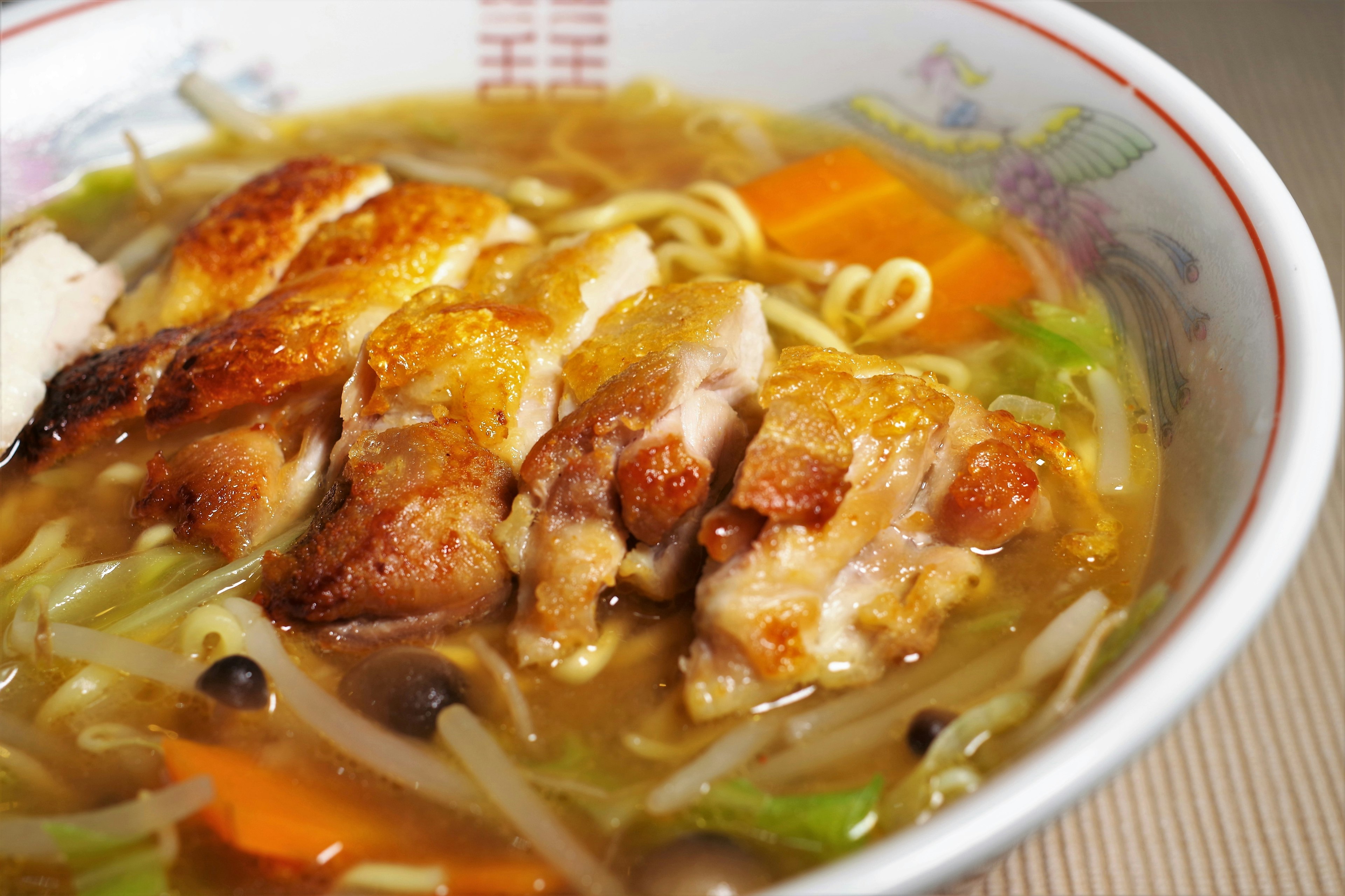 Ciotola di ramen con fette di pollo grigliato verdure colorate e brodo