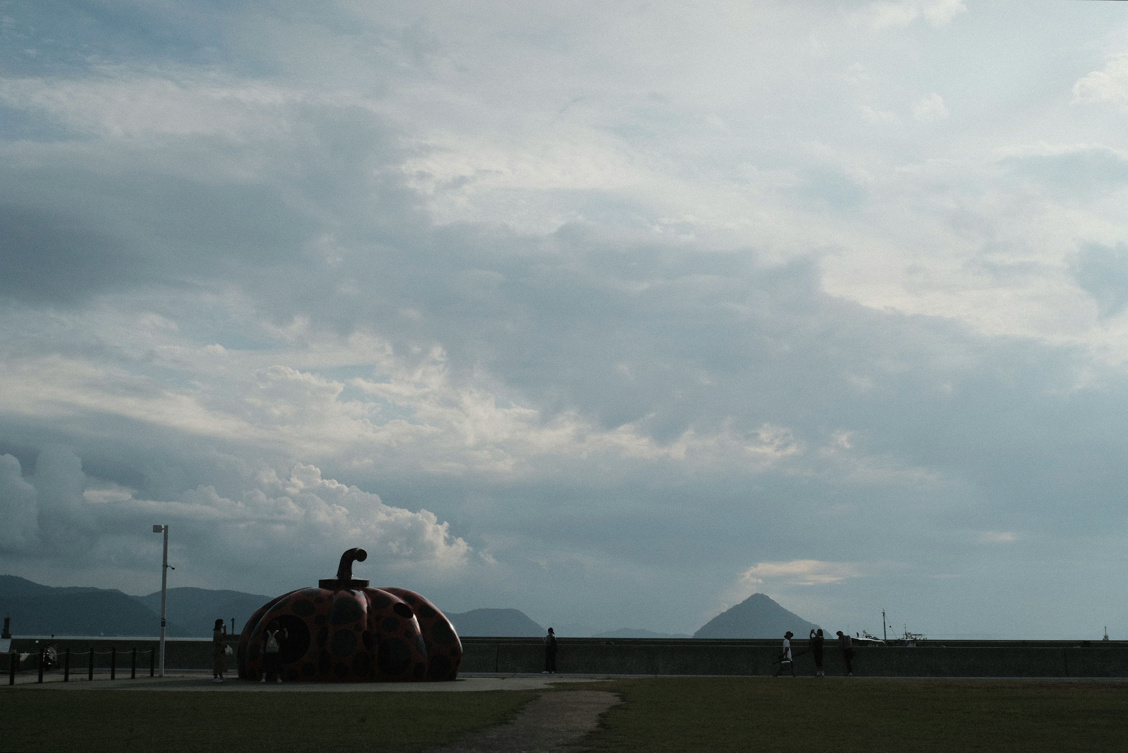 Sculpture de citrouille unique sous un ciel nuageux avec des montagnes lointaines