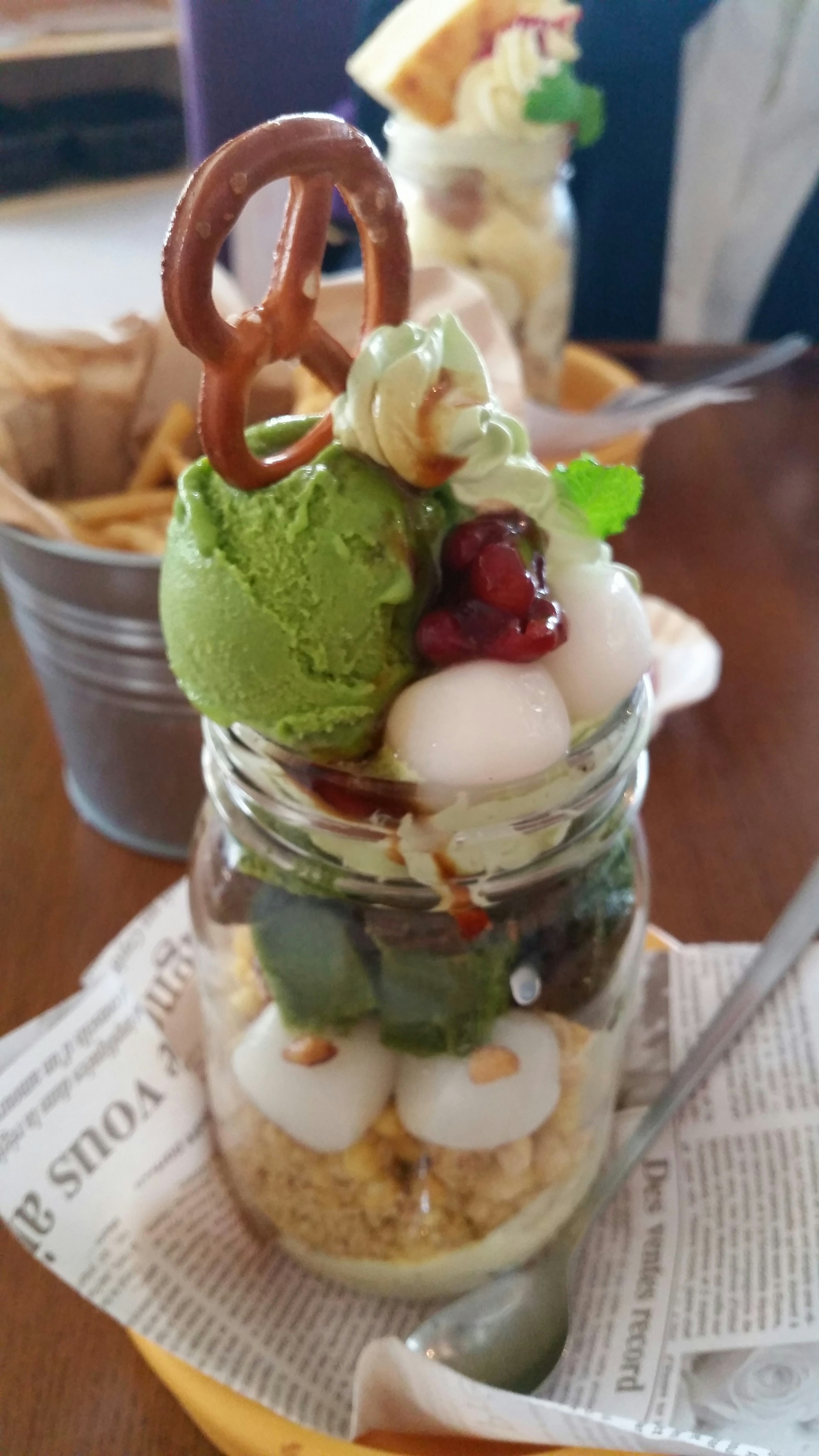 Dessert jar filled with green tea ice cream and assorted toppings