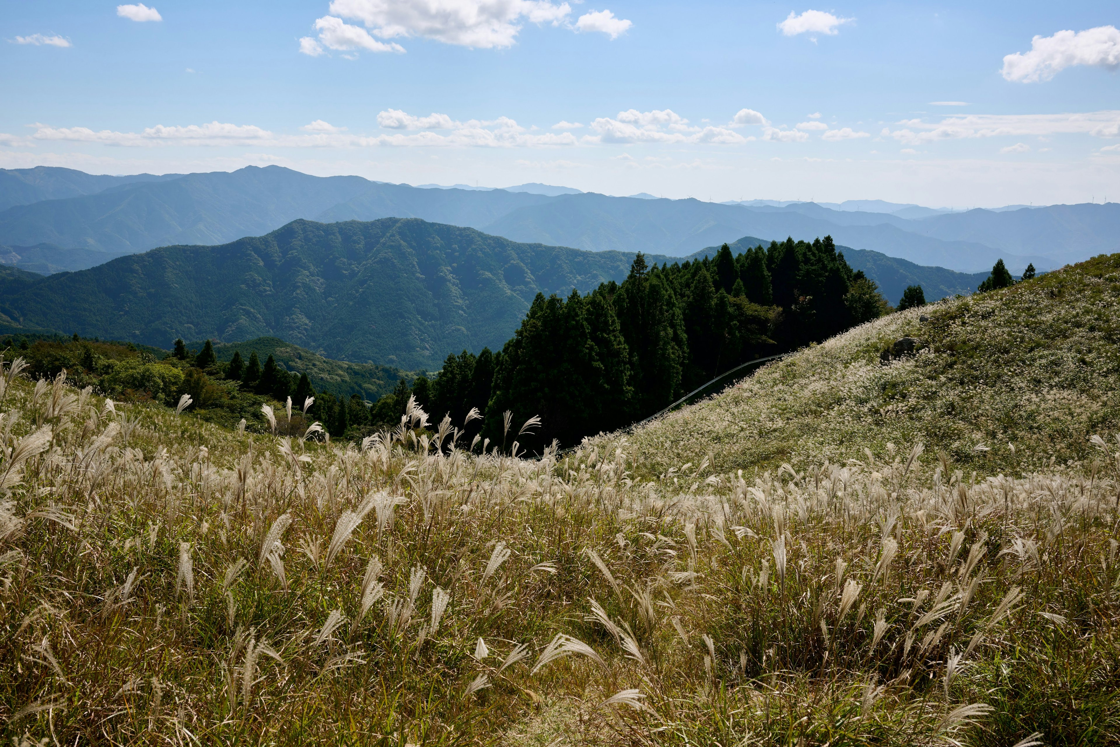 青い空と雲の下の山々と草原の風景