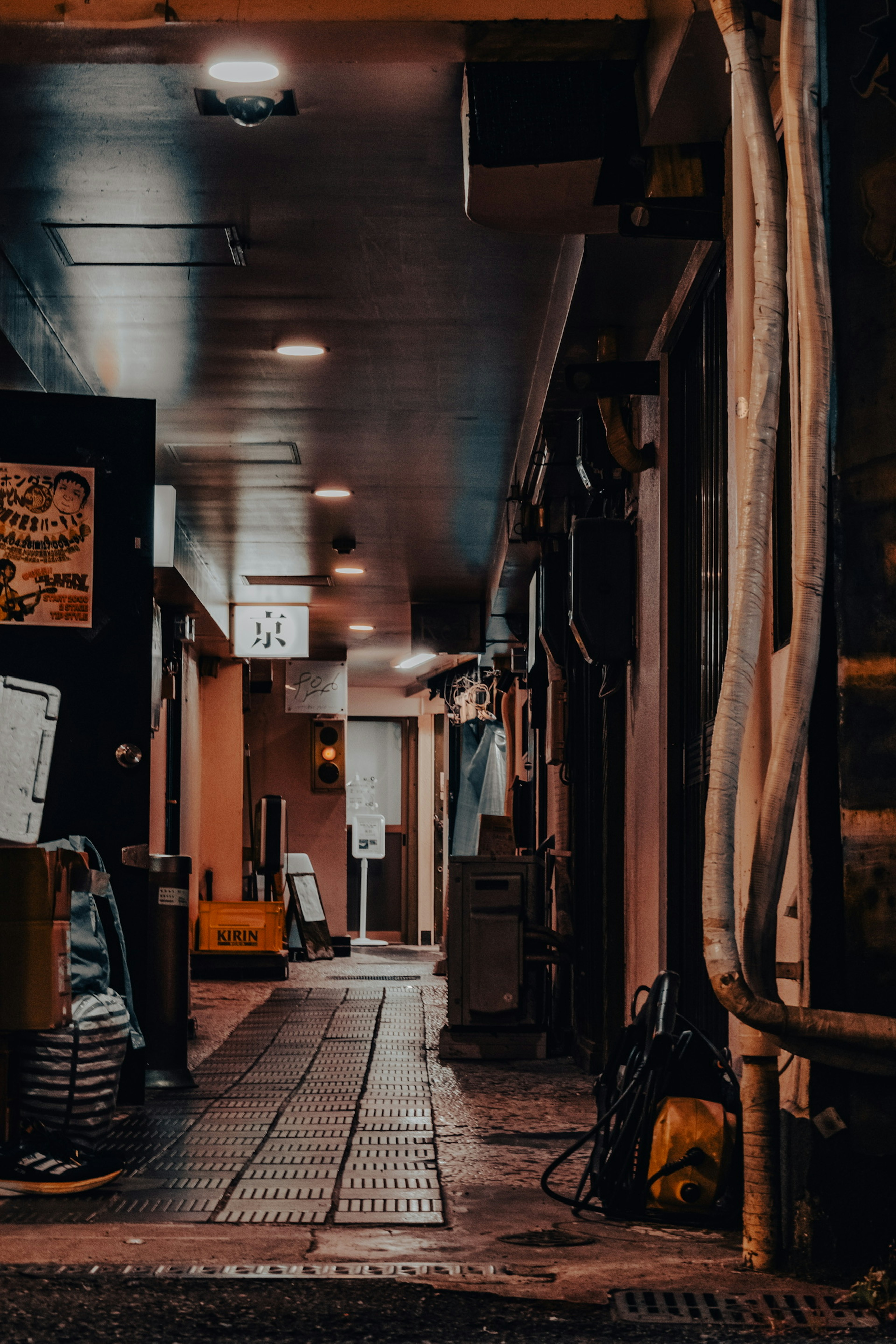 Lorong redup dengan ruang komersial dan papan nama