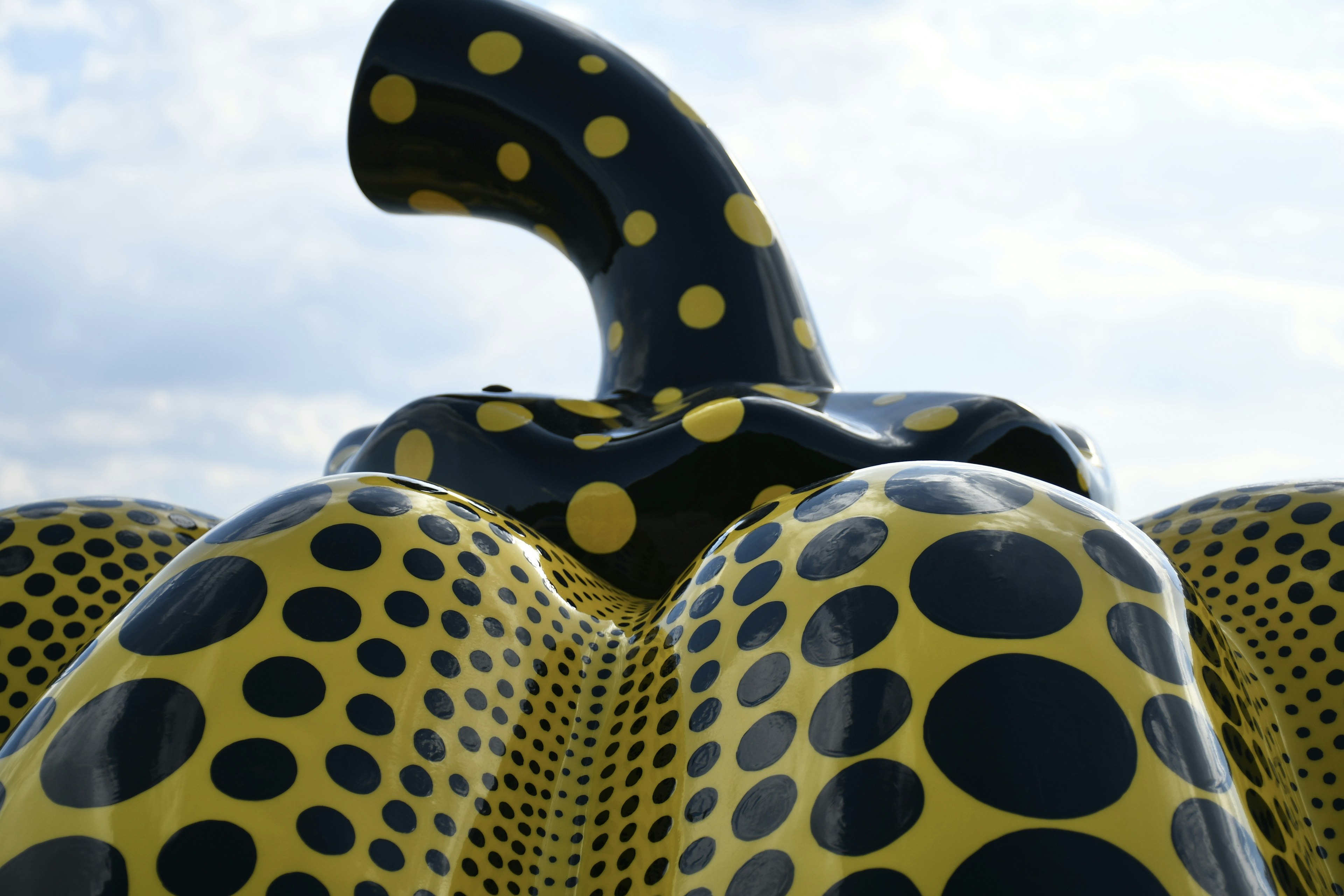 Art sculpture featuring a black and yellow polka dot design with a unique shape