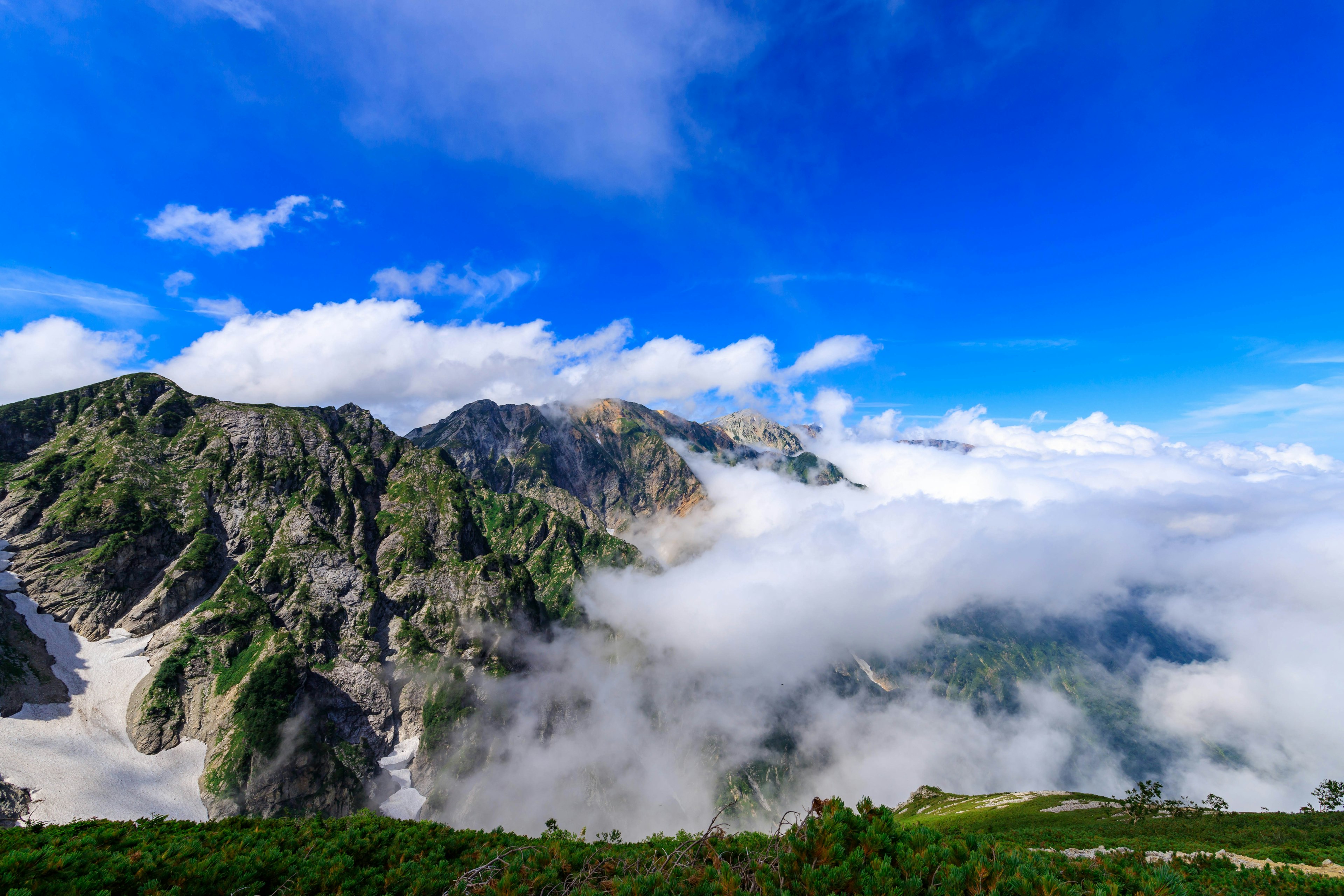 Berglandschaft umgeben von blauem Himmel und Wolken