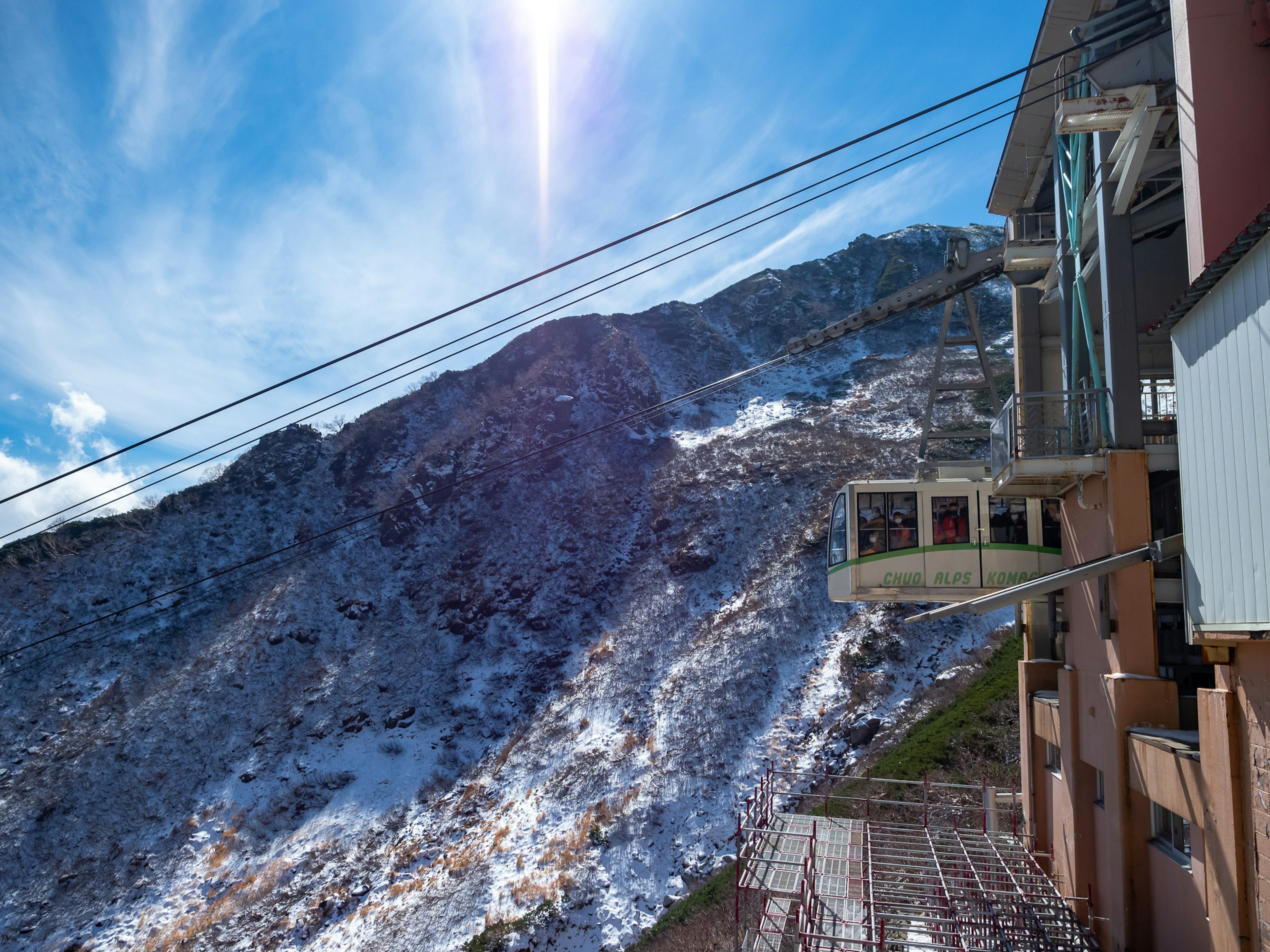 Paysage de montagne avec de la neige et un ciel bleu clair à côté d'un bâtiment