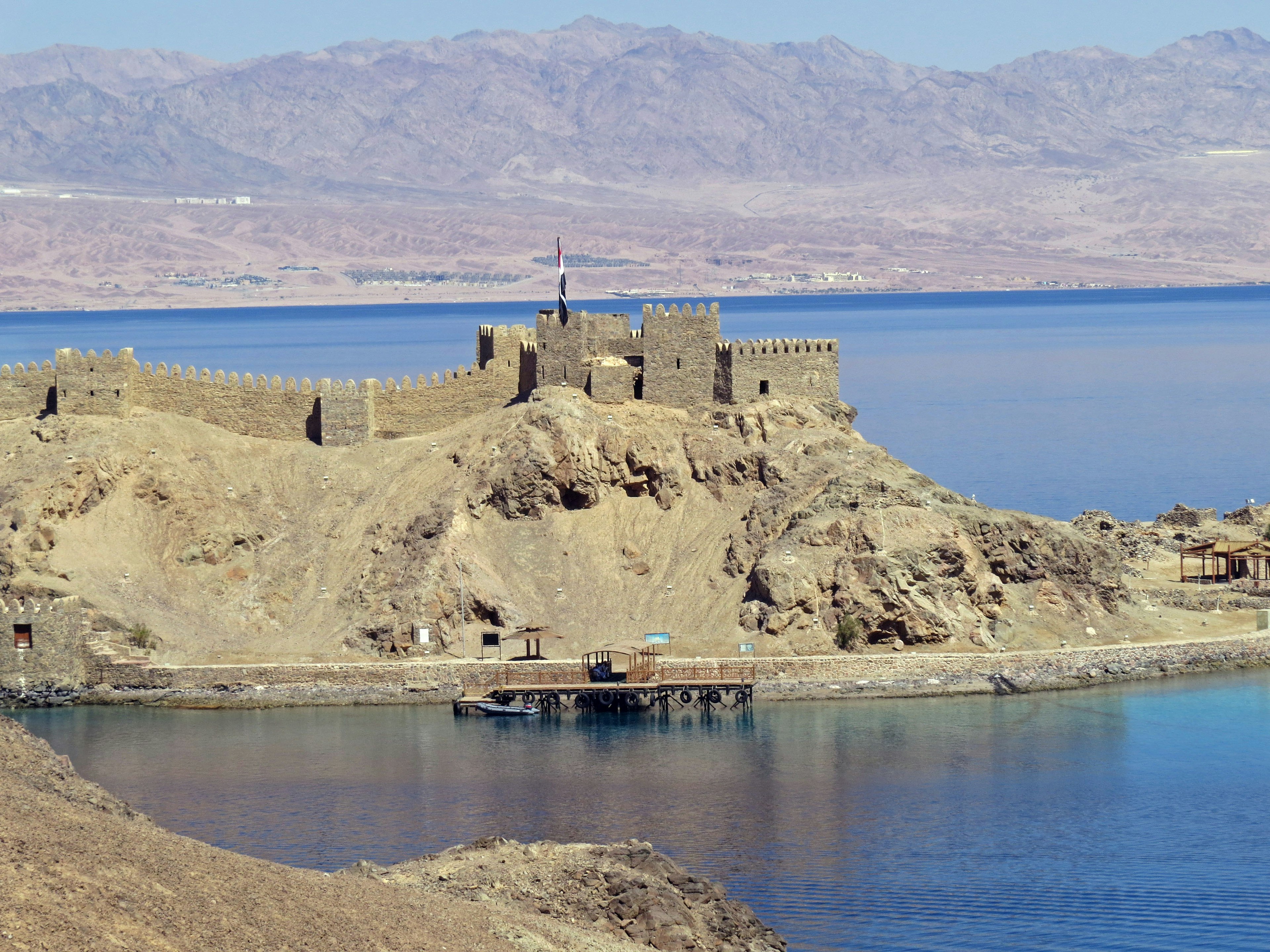 Ancient castle ruins surrounded by water and mountains