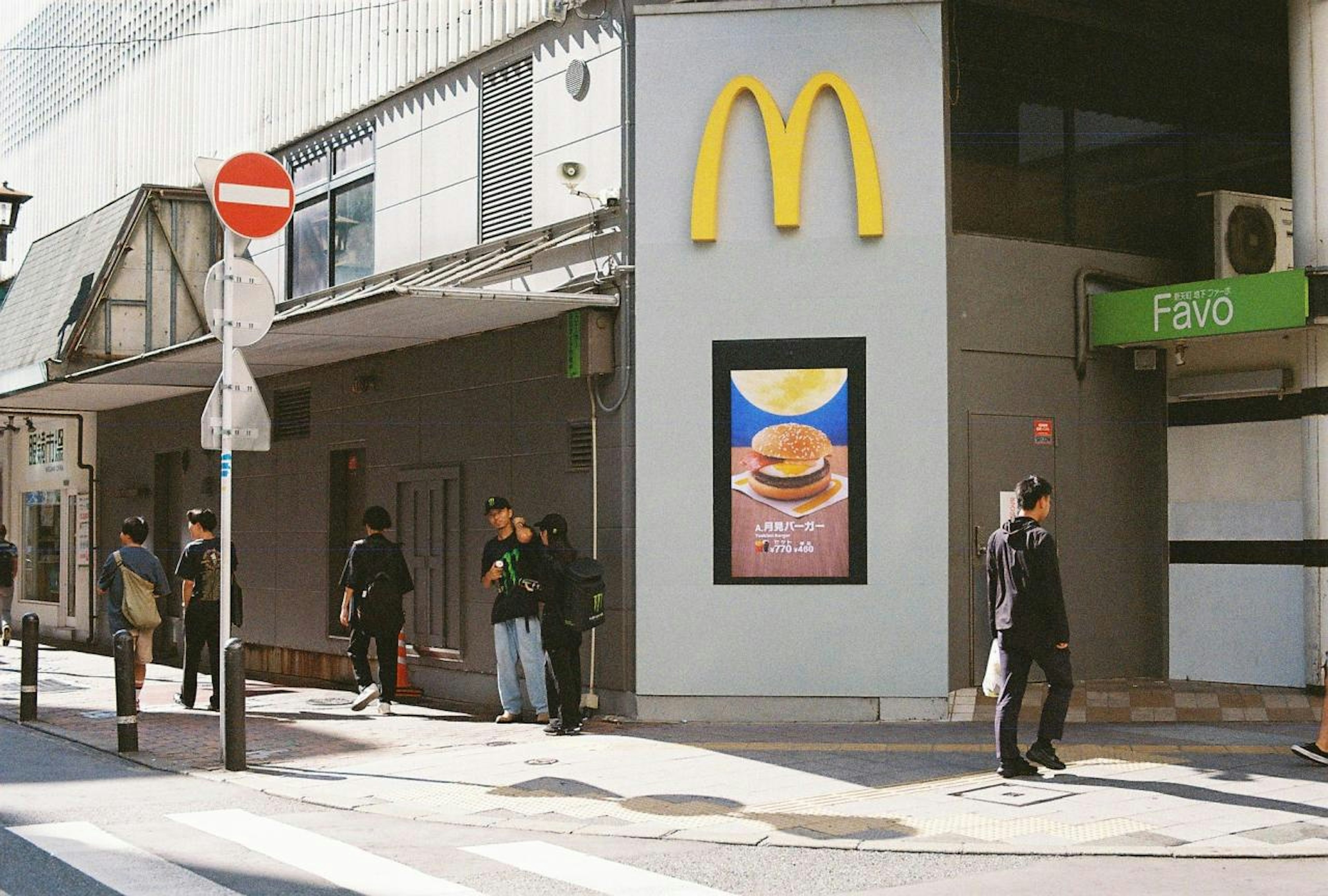 マクドナルドの看板がある街角の風景 人々が歩いている