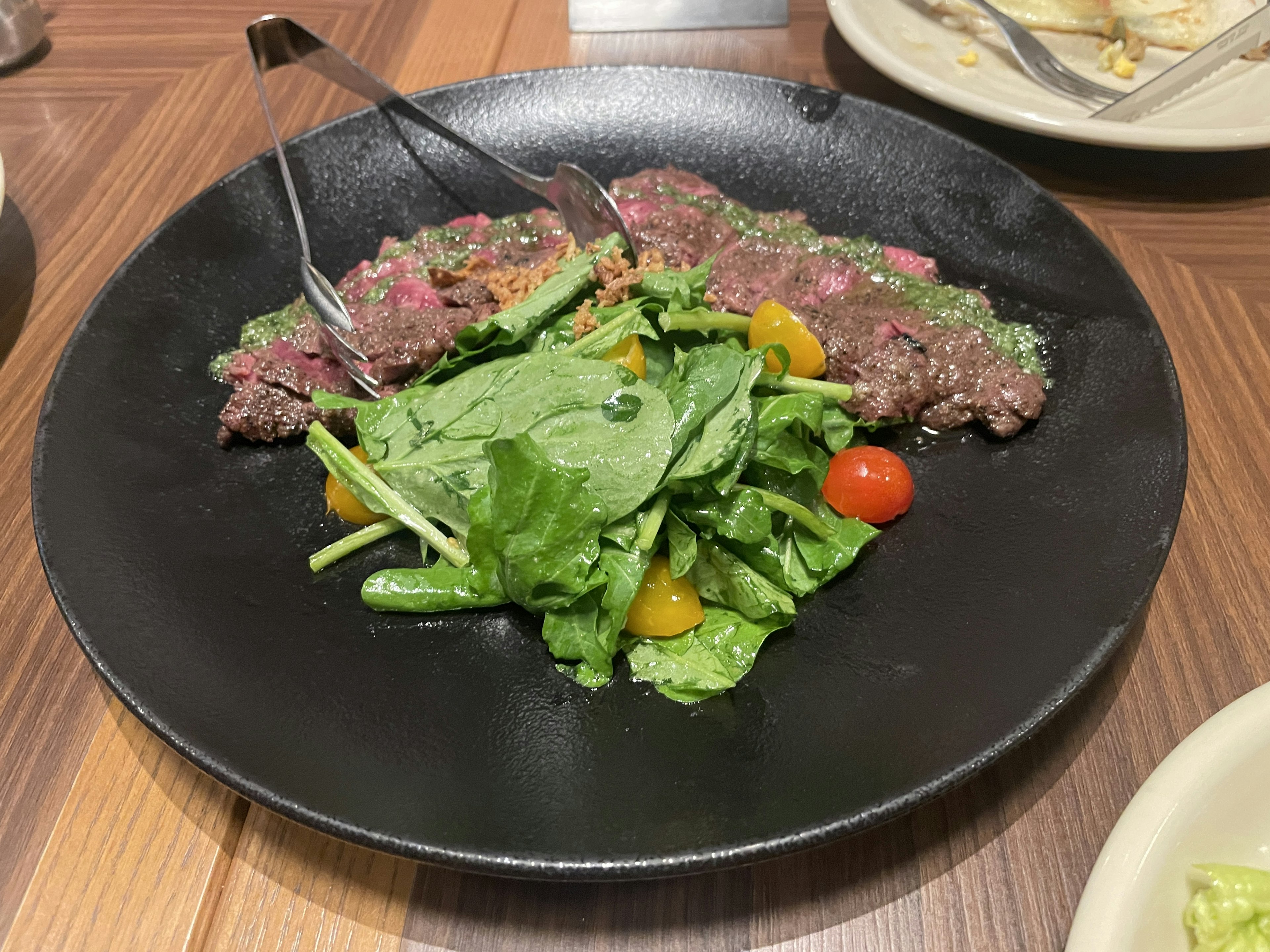 Teller mit geschnittenem Steak und frischem Salat mit Kirschtomaten