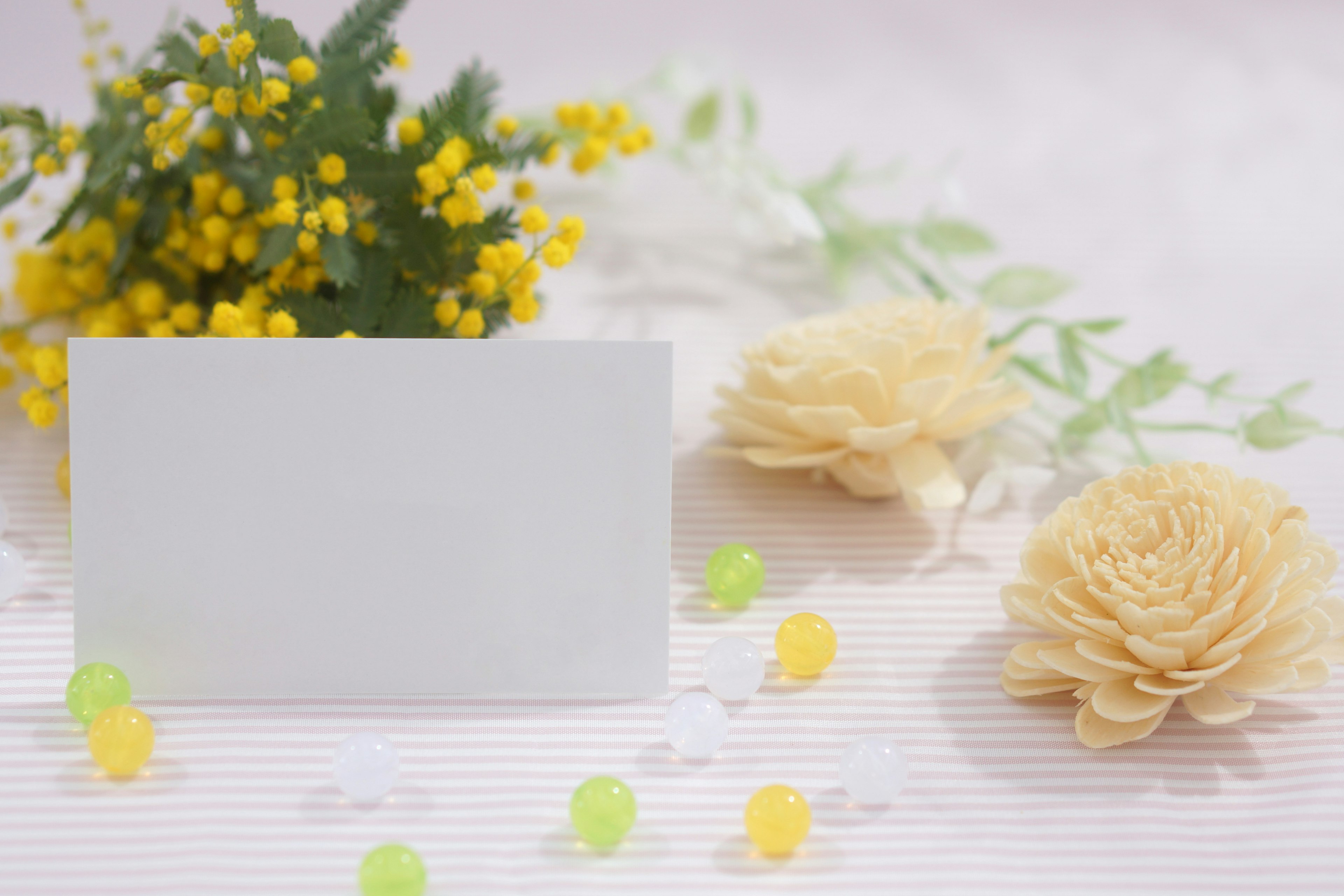 Plain card surrounded by pale flowers and small yellow blooms