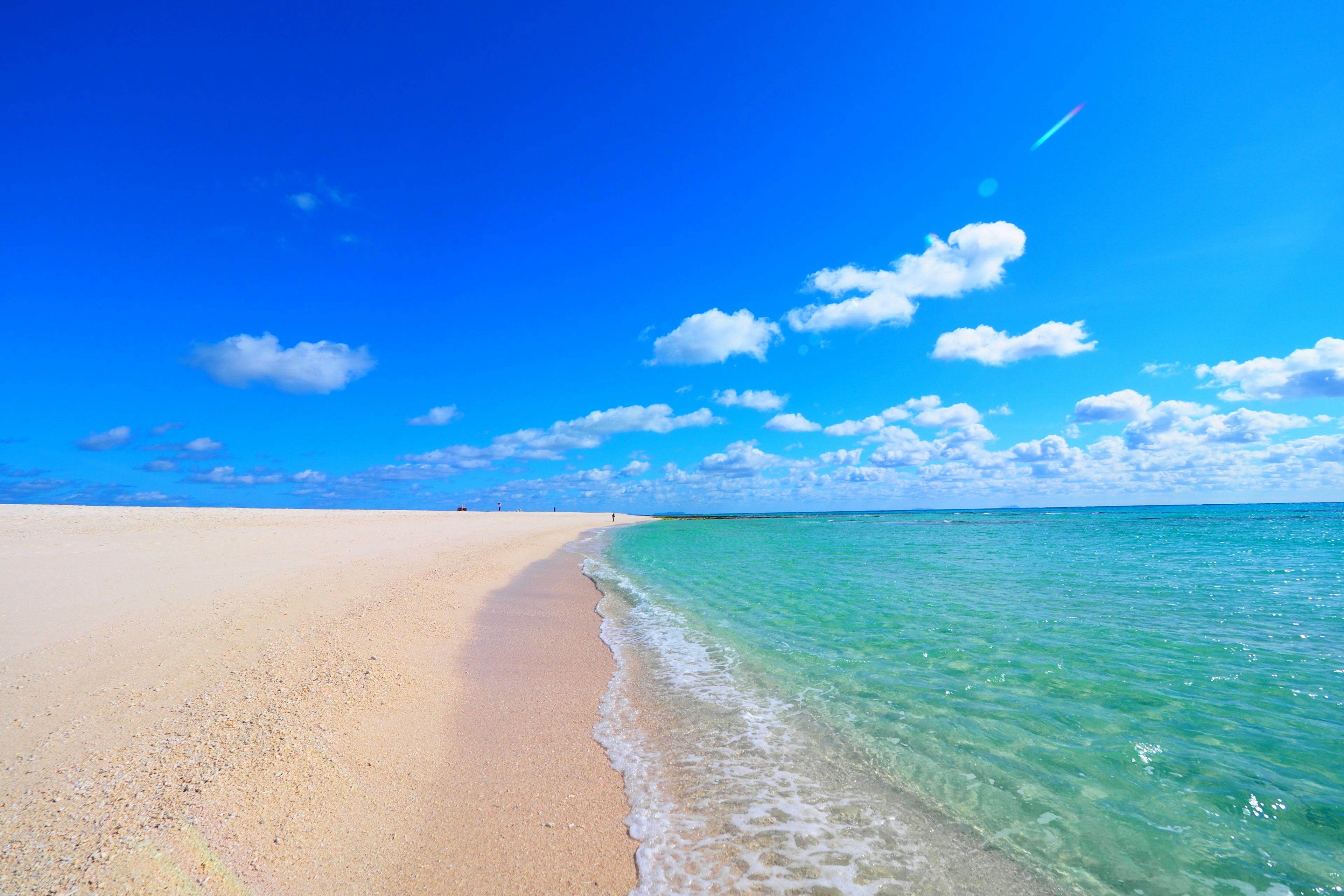 Vista escénica de una playa con cielo azul y arena blanca