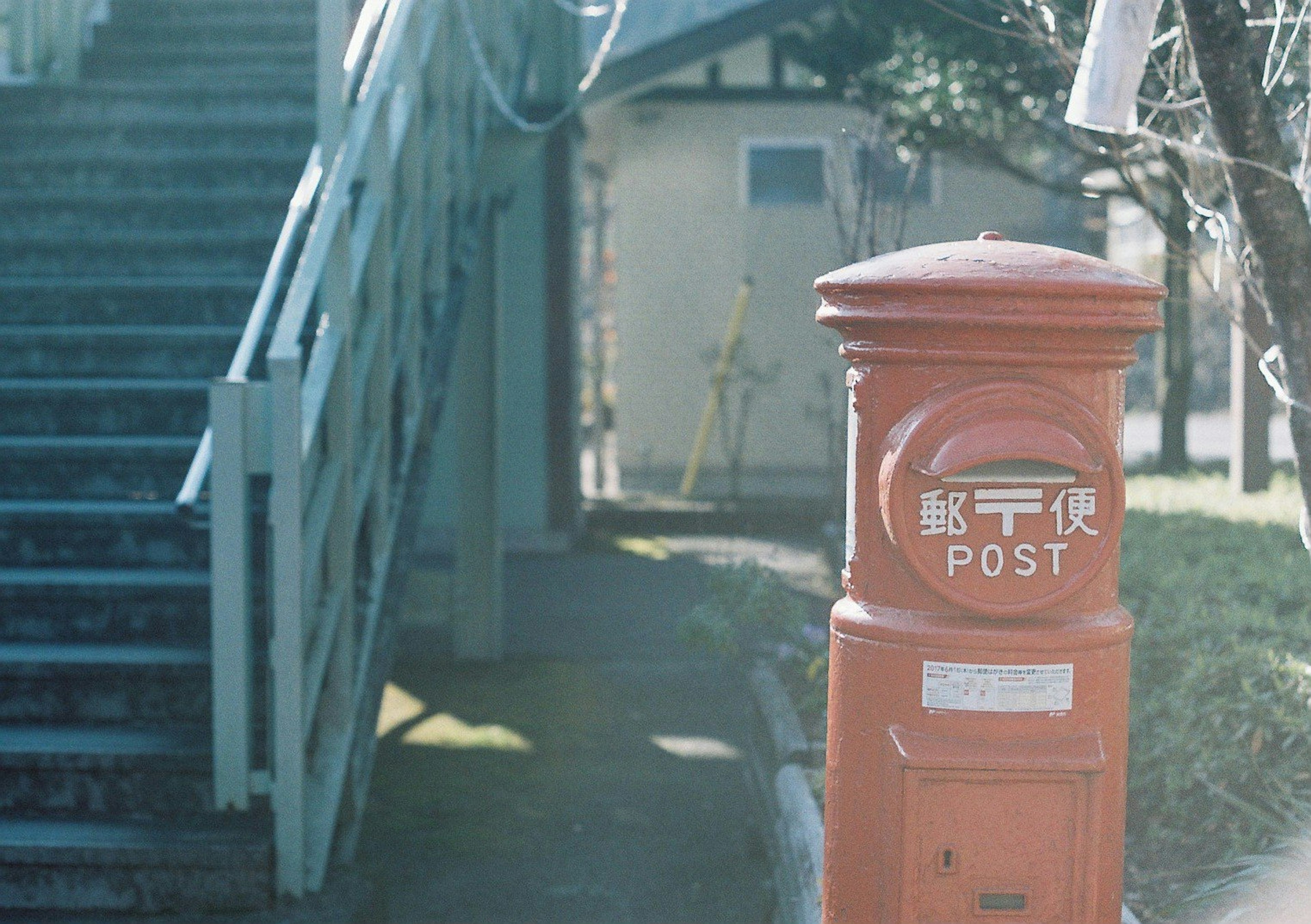 Red postal box next to stairs in a quiet setting