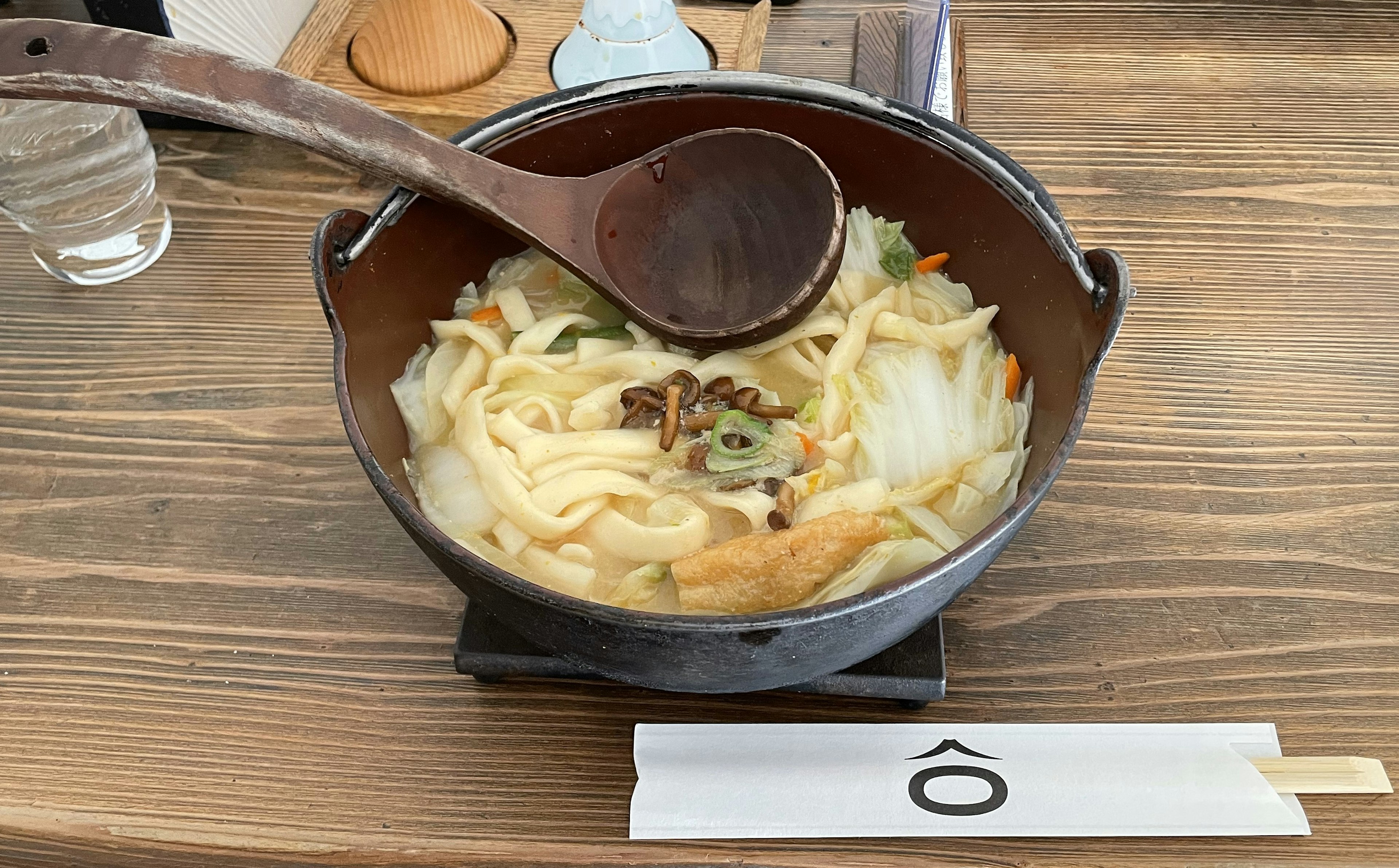 Tazón de fideos udon calientes con cuchara de madera