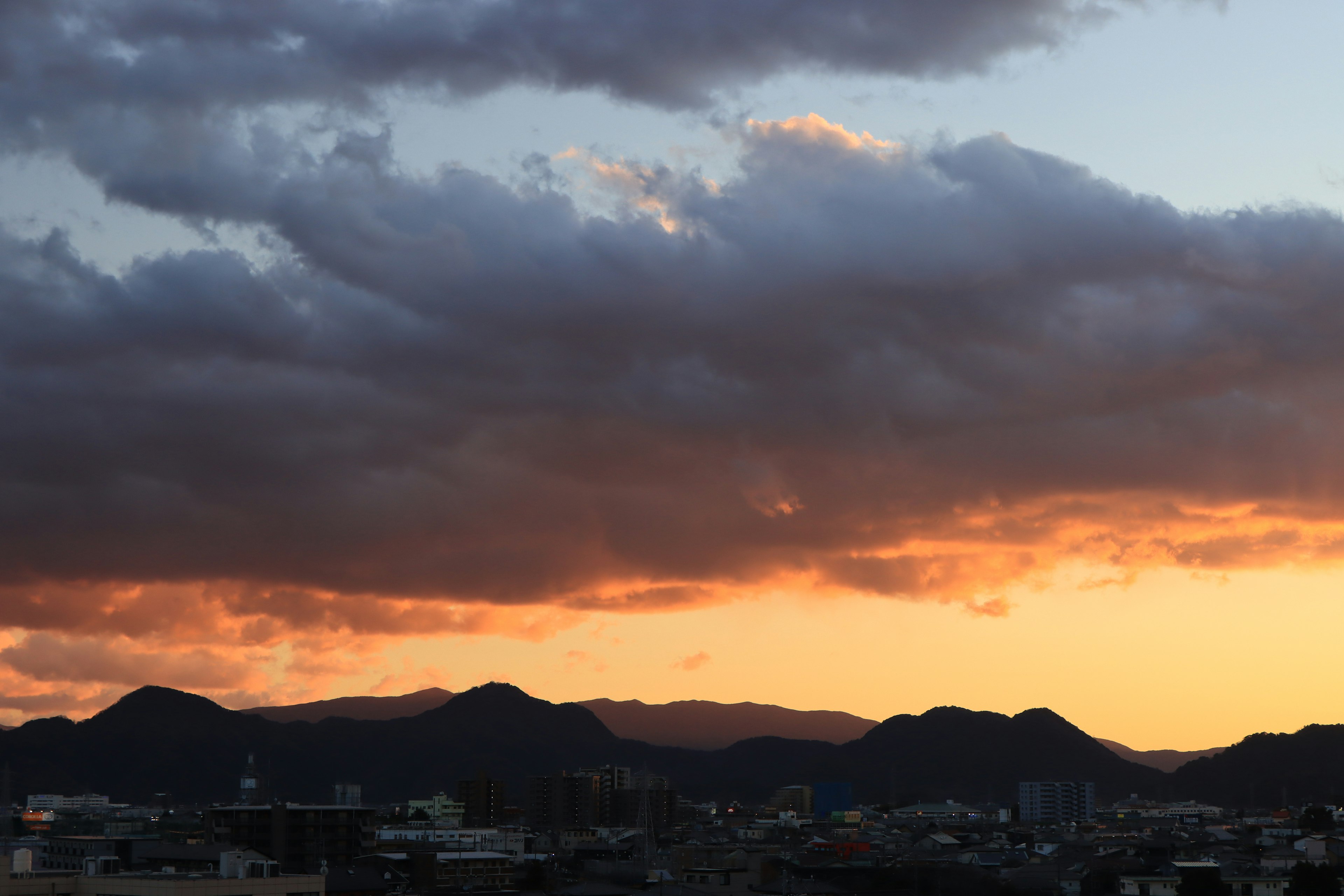 夕焼けの空と山々のシルエットが美しい風景