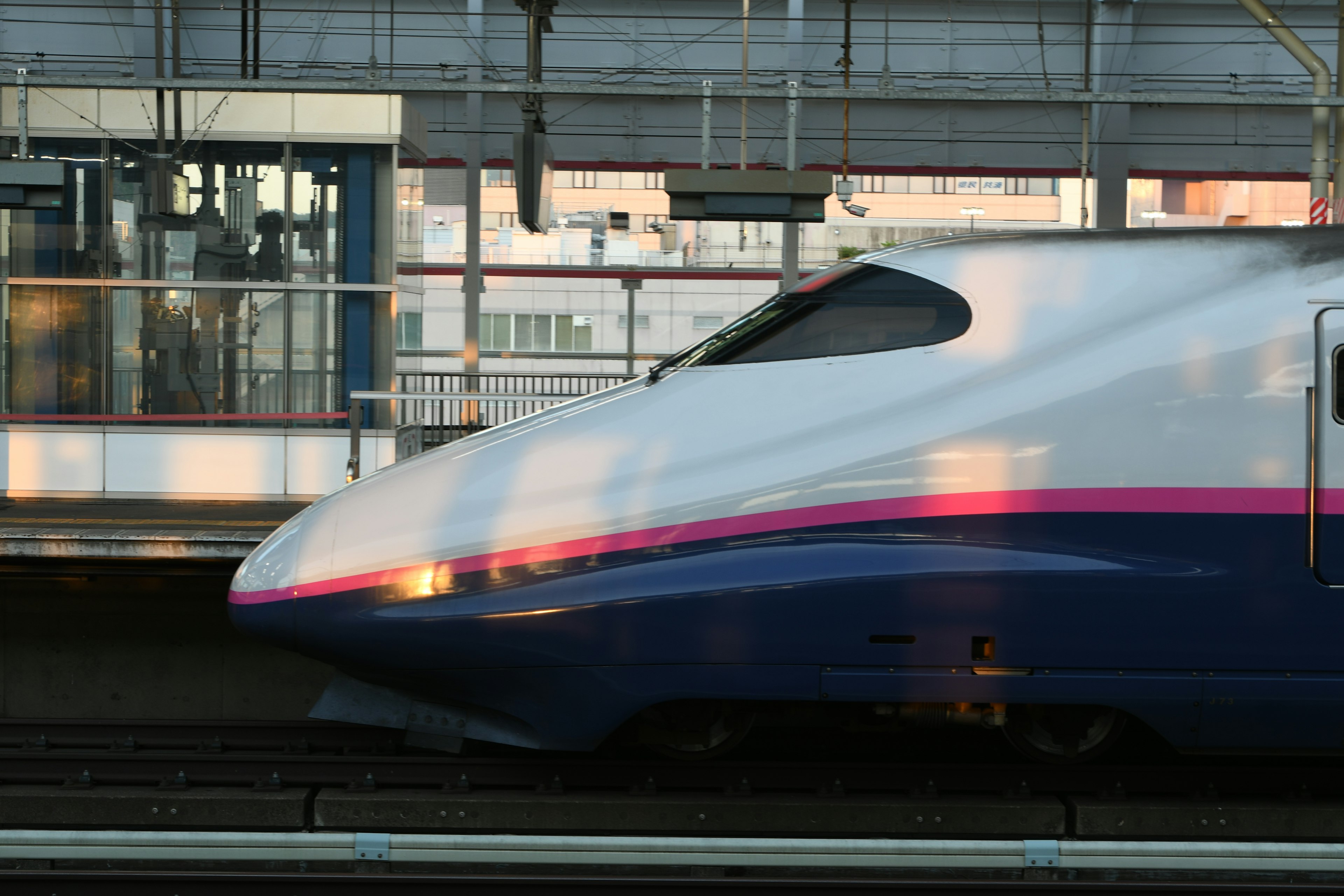 新幹線の側面が駅で停車中の画像