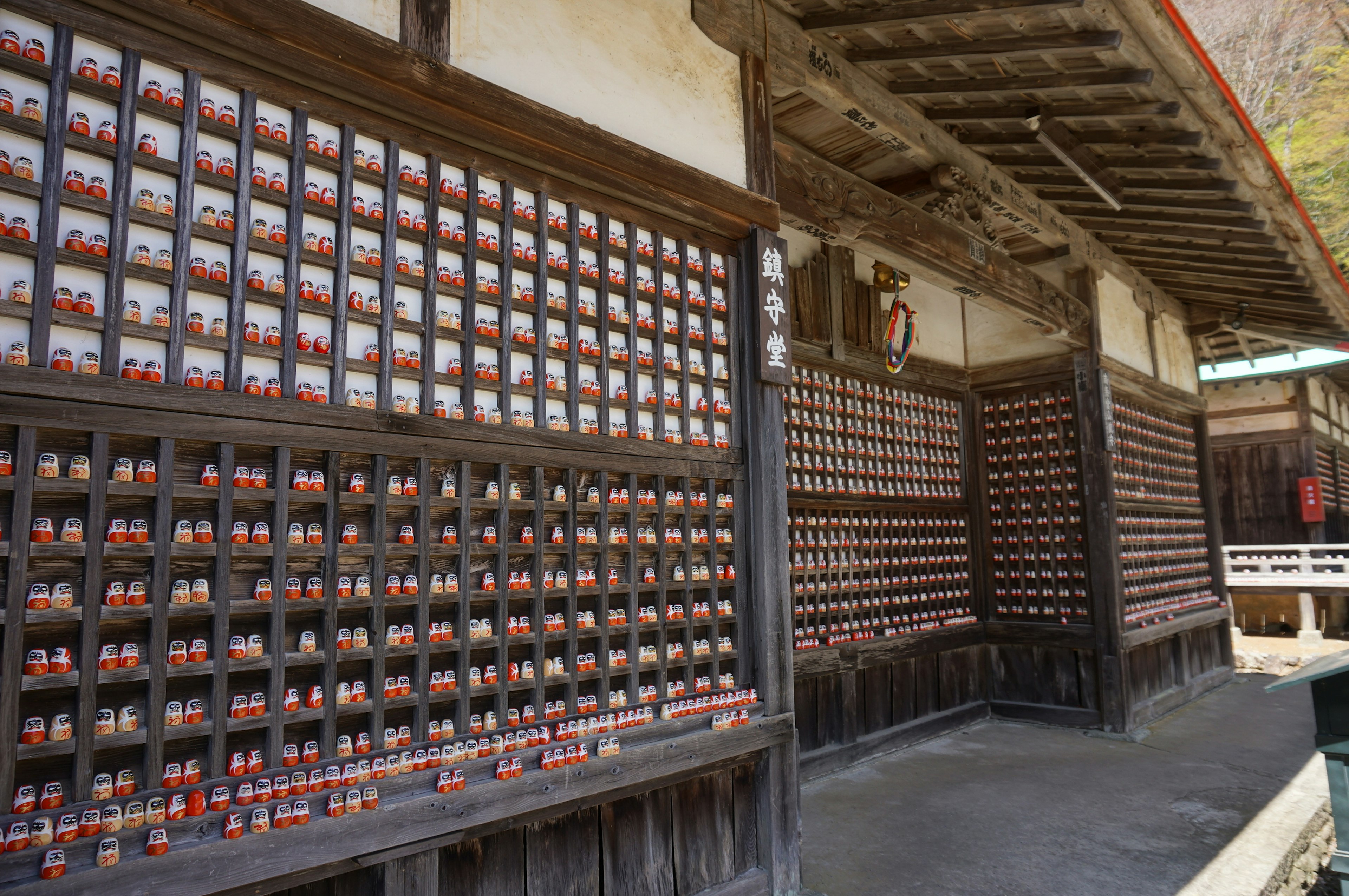 Wand eines traditionellen japanischen Gebäudes mit kleinen roten Amulettkästen