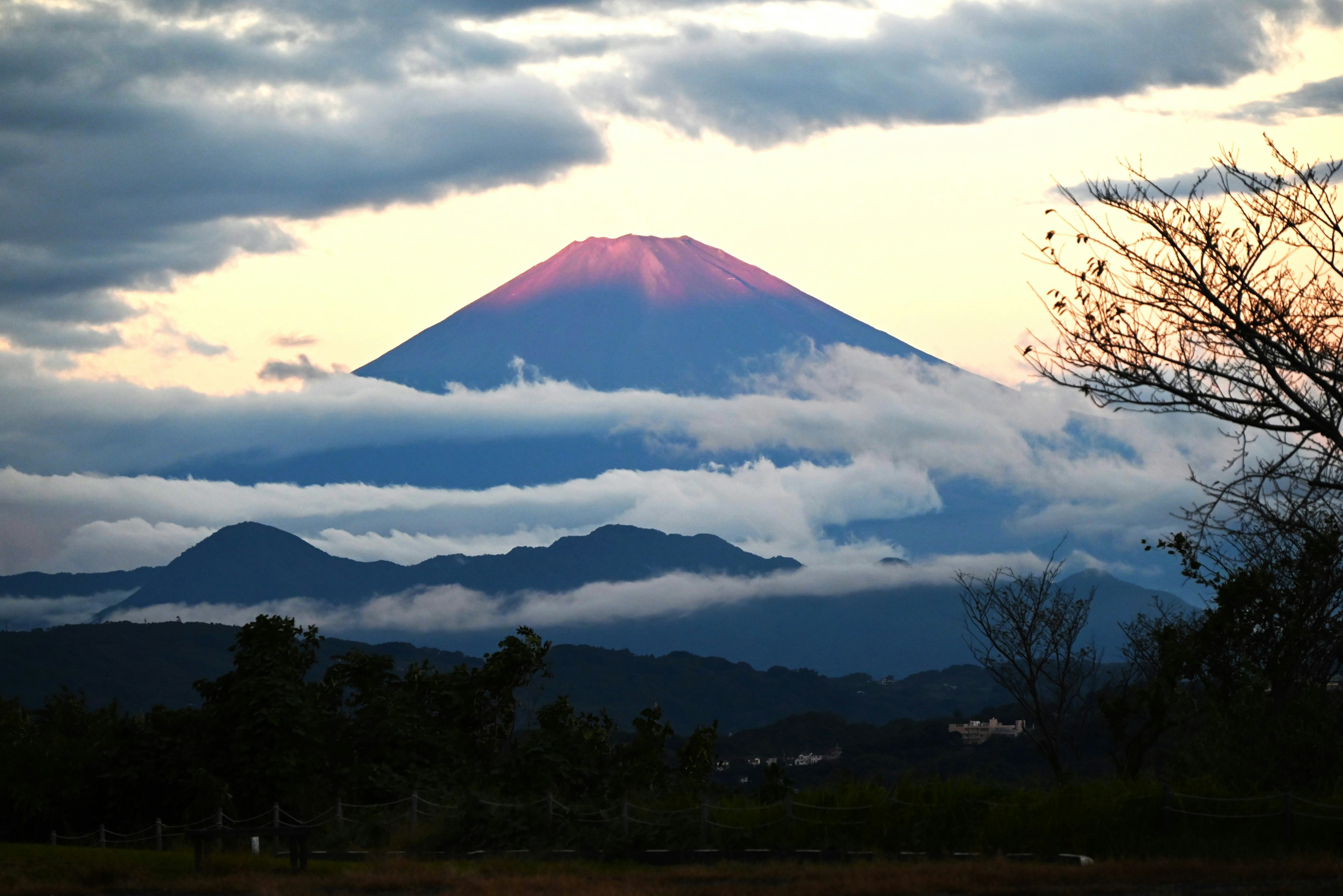 Monte Fuji illuminato dal tramonto con nuvole e colline lontane