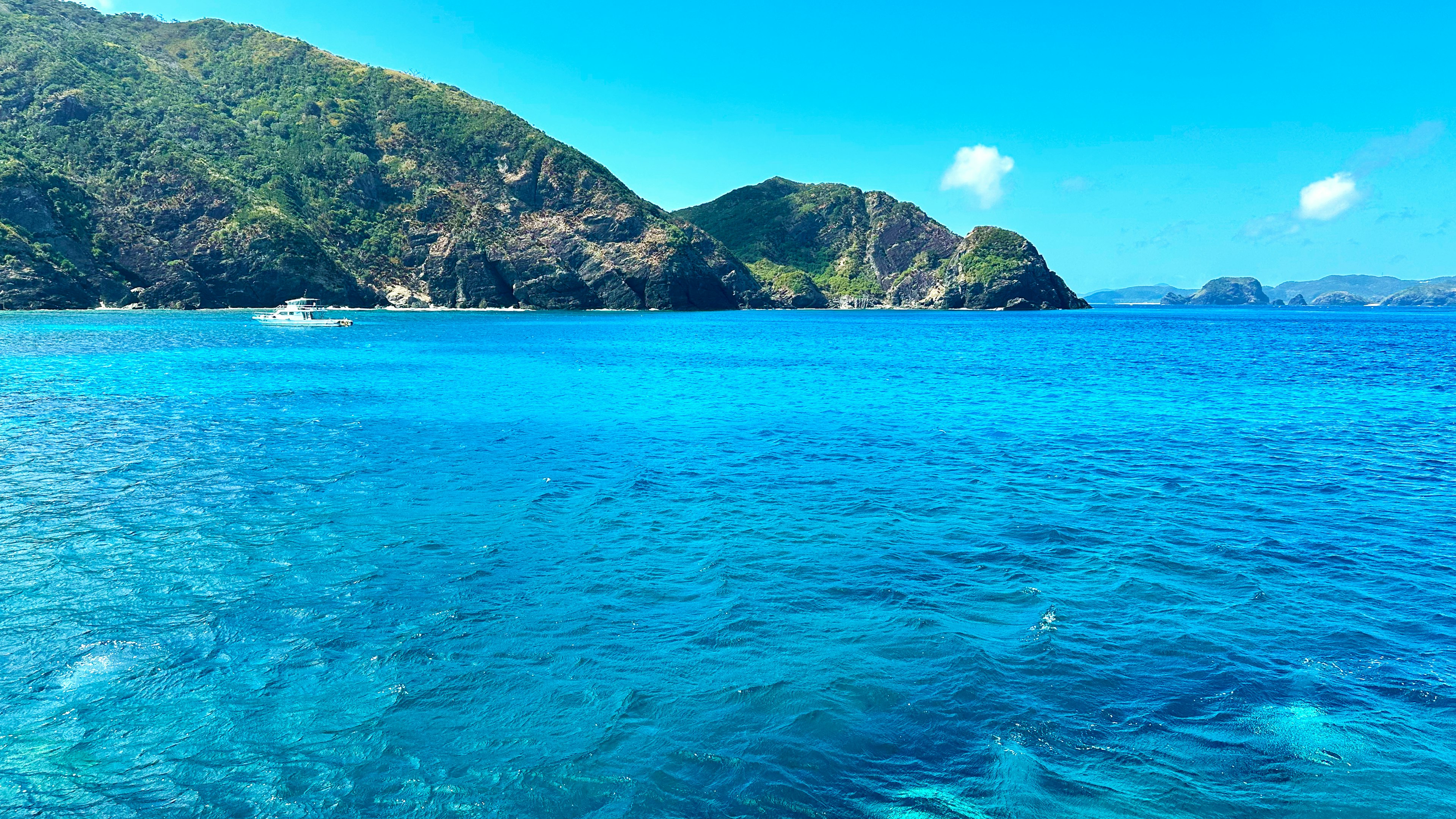 Pemandangan indah dengan laut biru dan gunung hijau