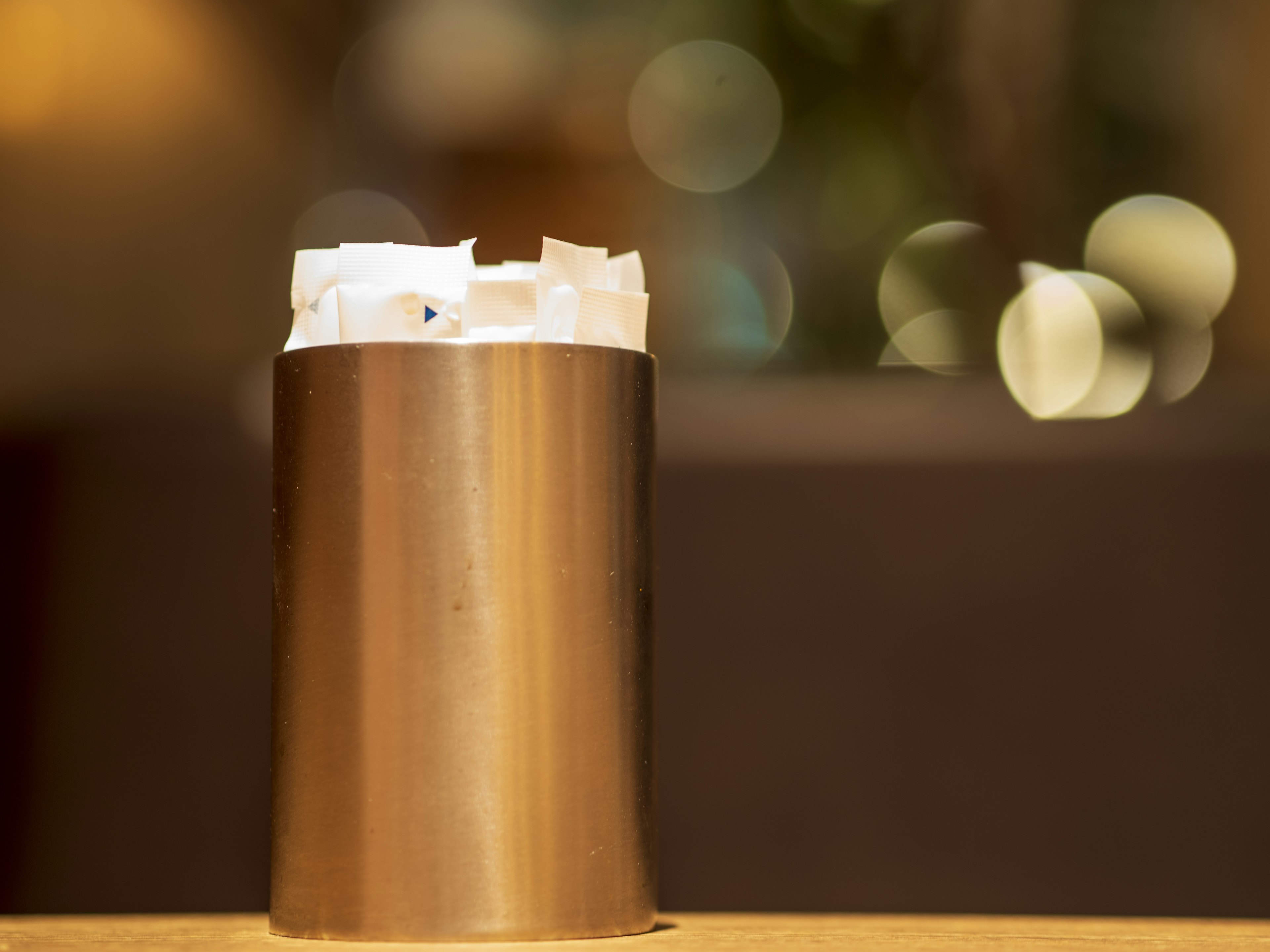 Metal container with crumpled paper at the top blurred green light in the background