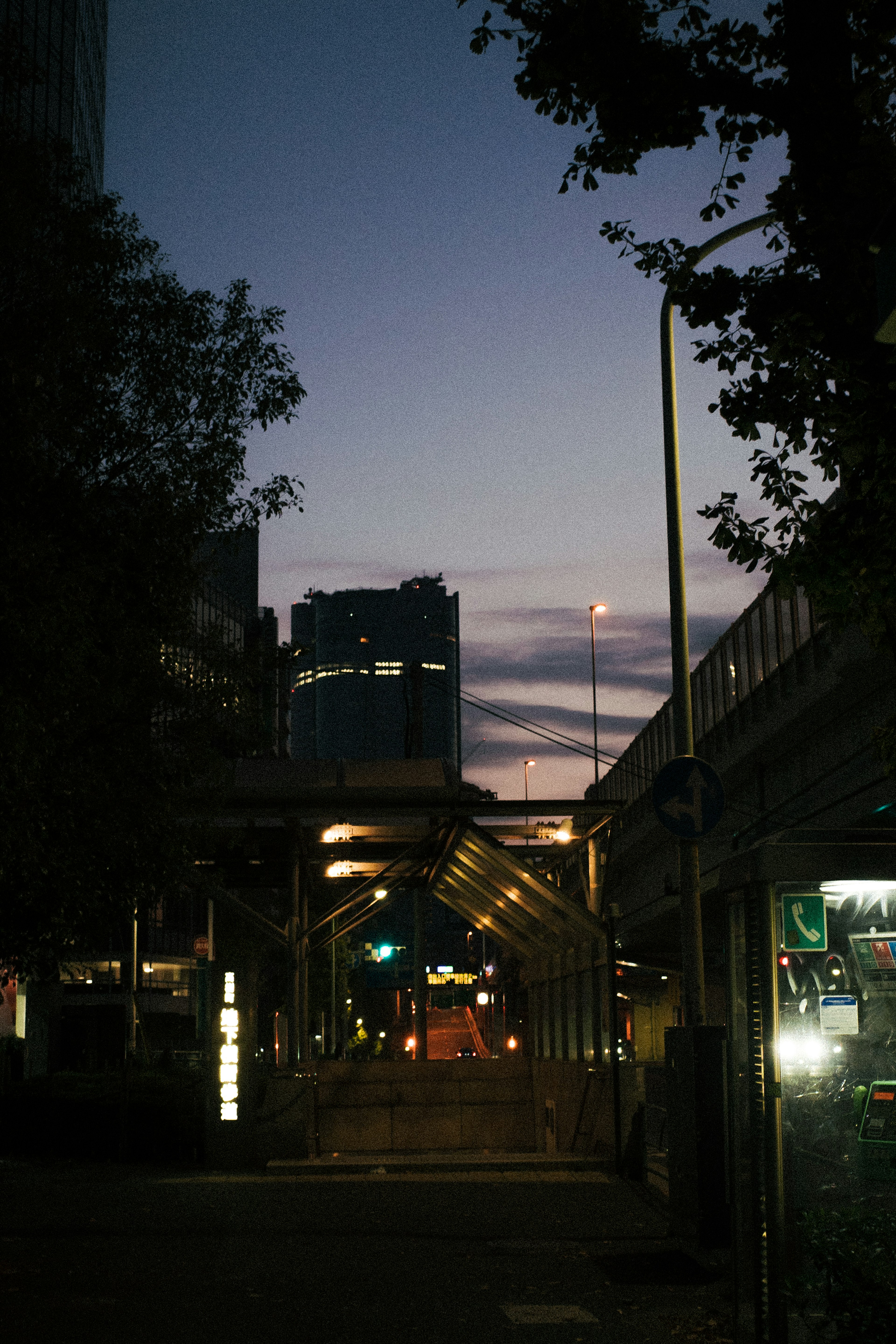 Urban landscape at dusk with buildings and streetlights visible