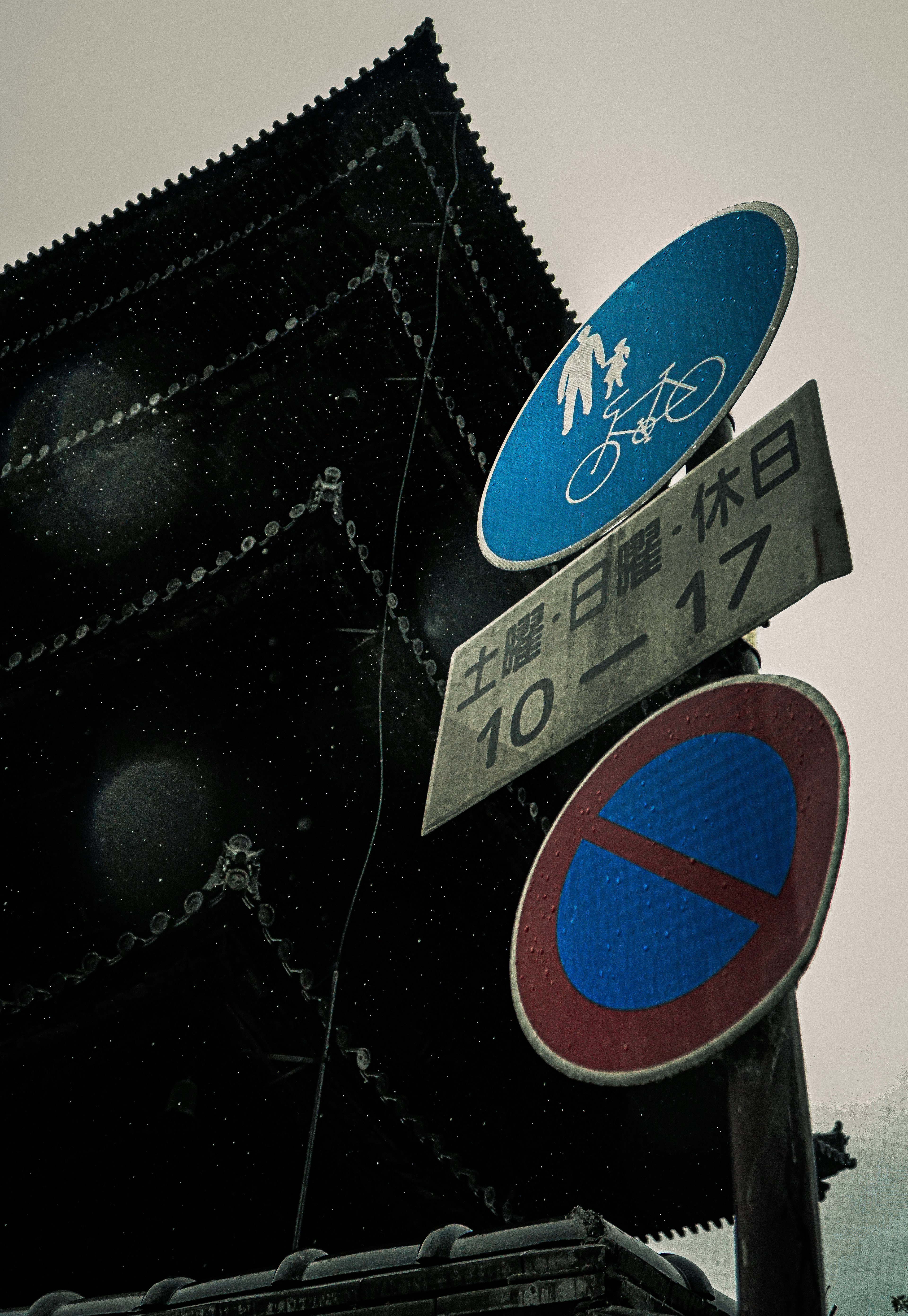 Traffic signs in the snow featuring bicycle and pedestrian icons