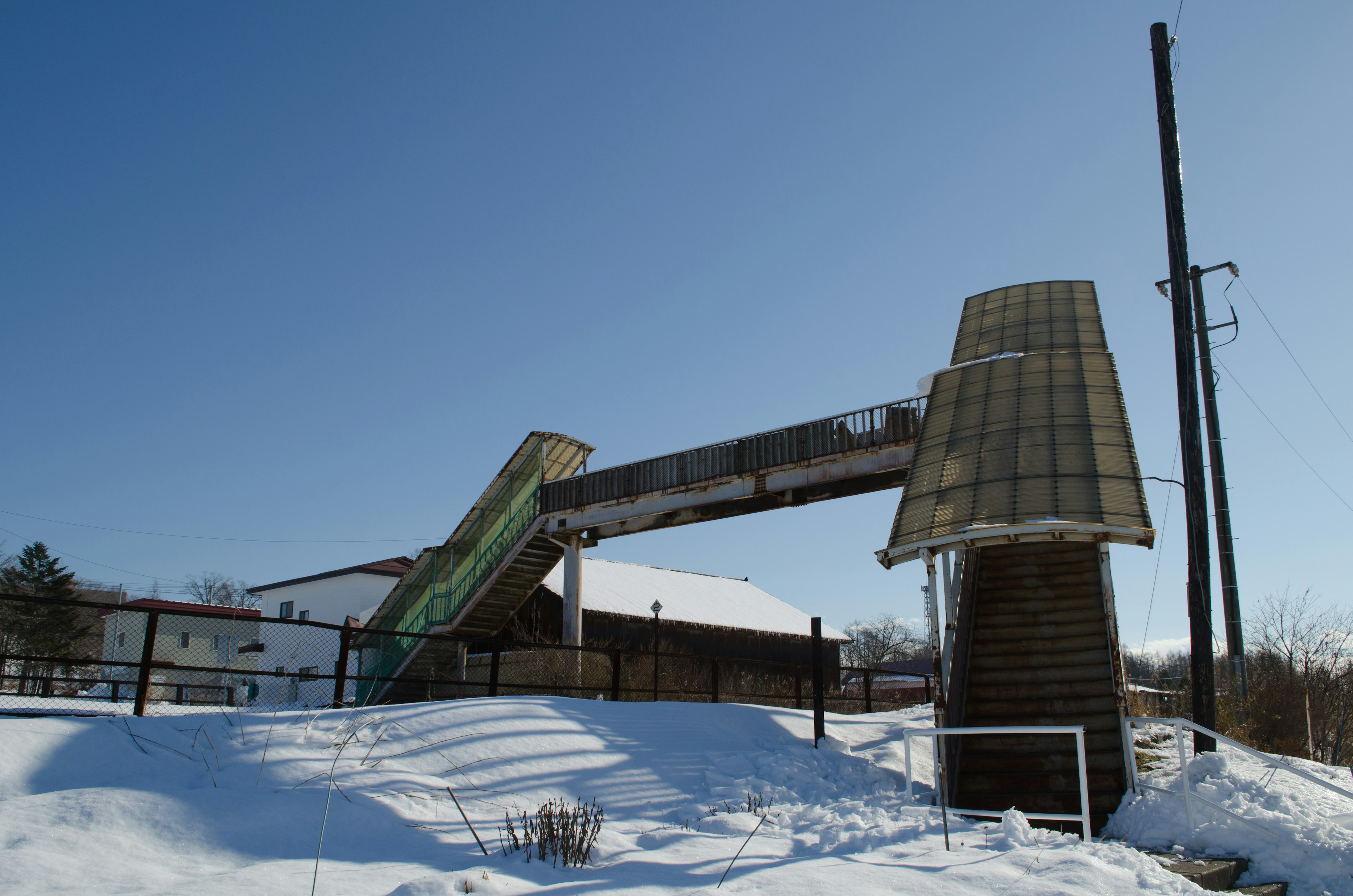 A snow-covered windmill with a clear blue sky