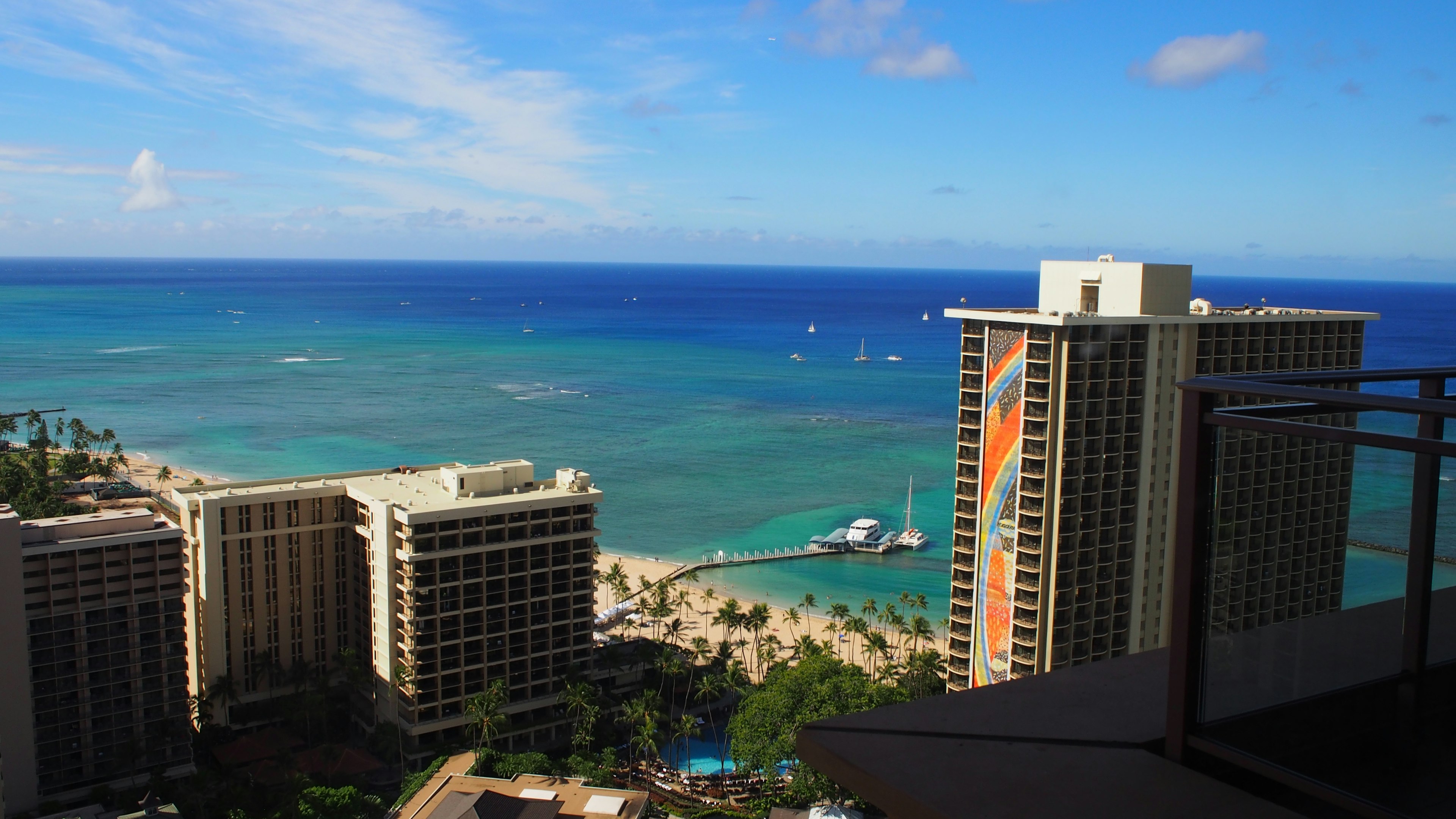 Pemandangan pantai dan laut Honolulu dengan gedung pencakar langit dan langit biru