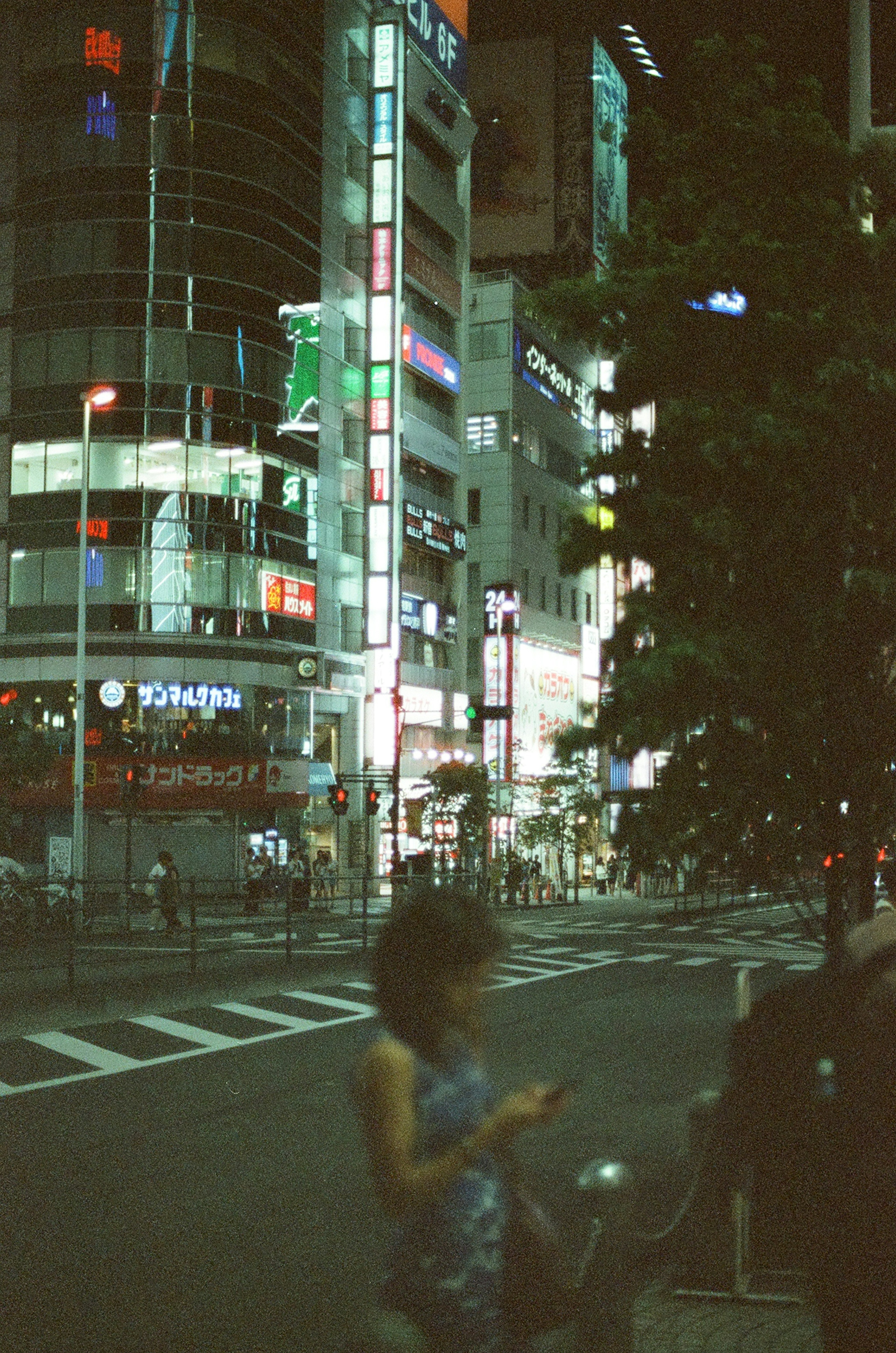 Woman standing in a night cityscape with bright neon signs